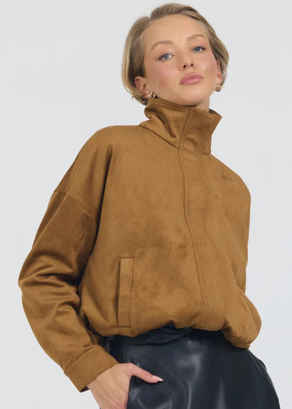 Woman wearing a brown suede jacket against a white background