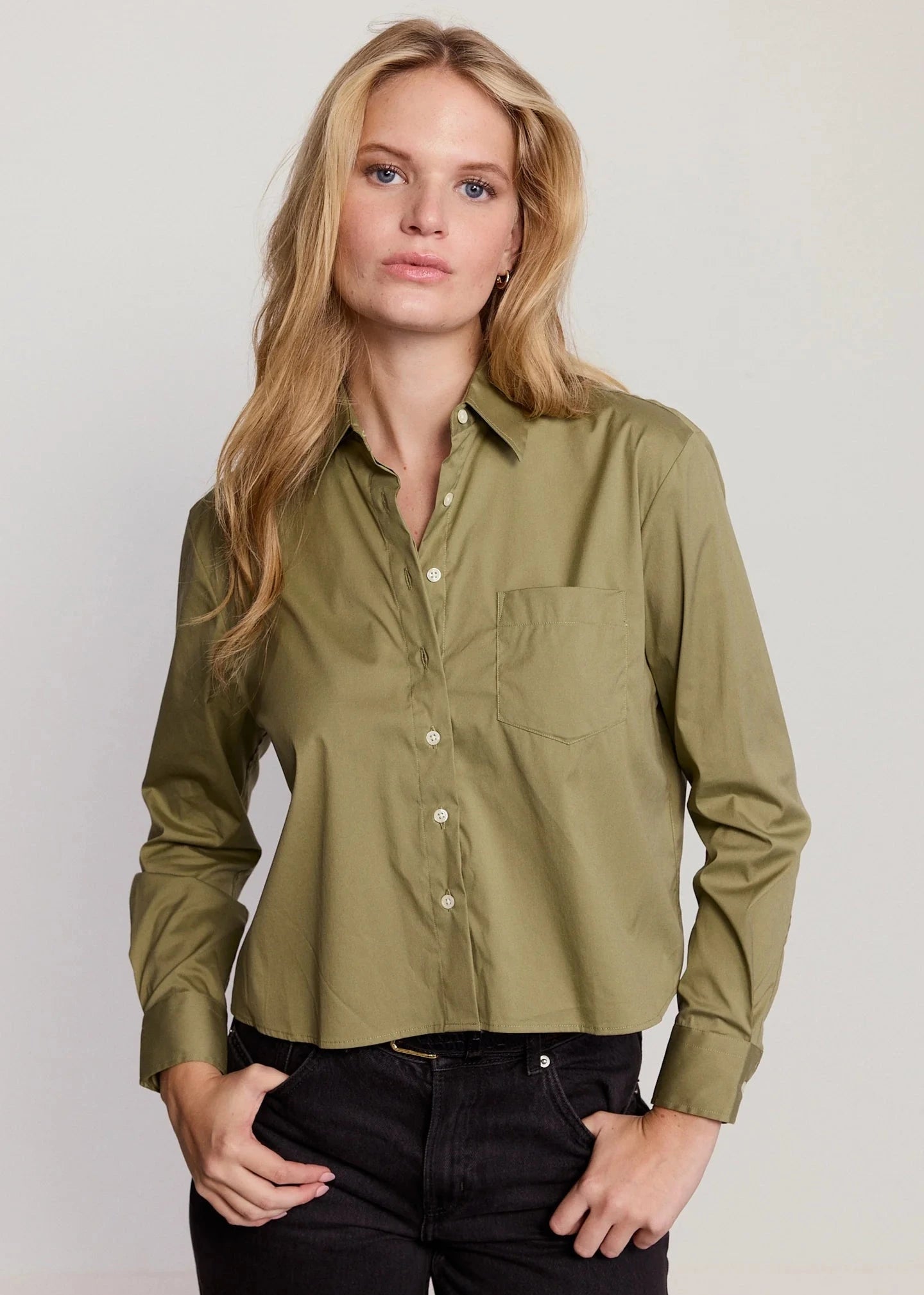 Woman wearing a green shirt against a plain background