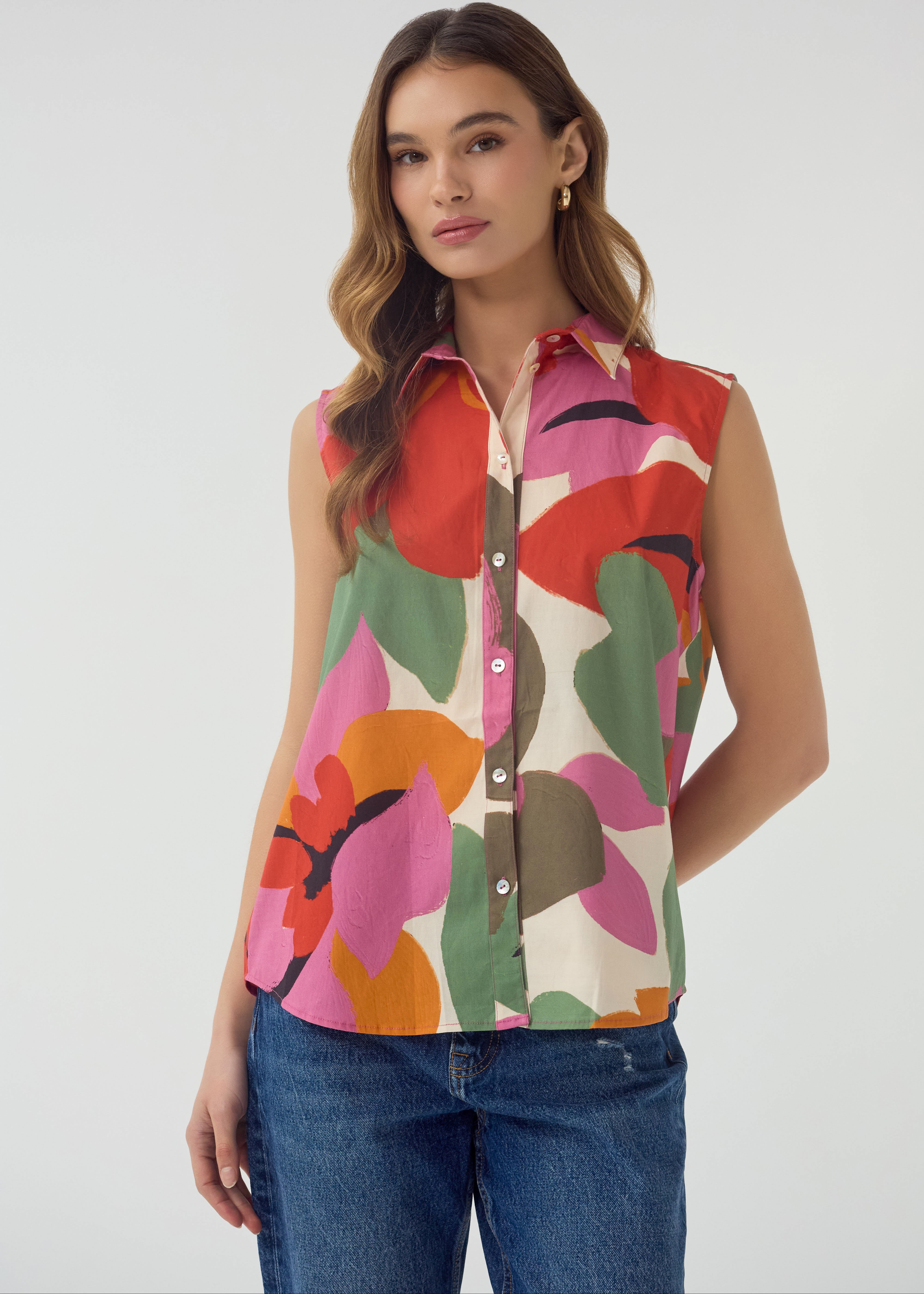 Woman wearing a colorful sleeveless shirt with a white background
