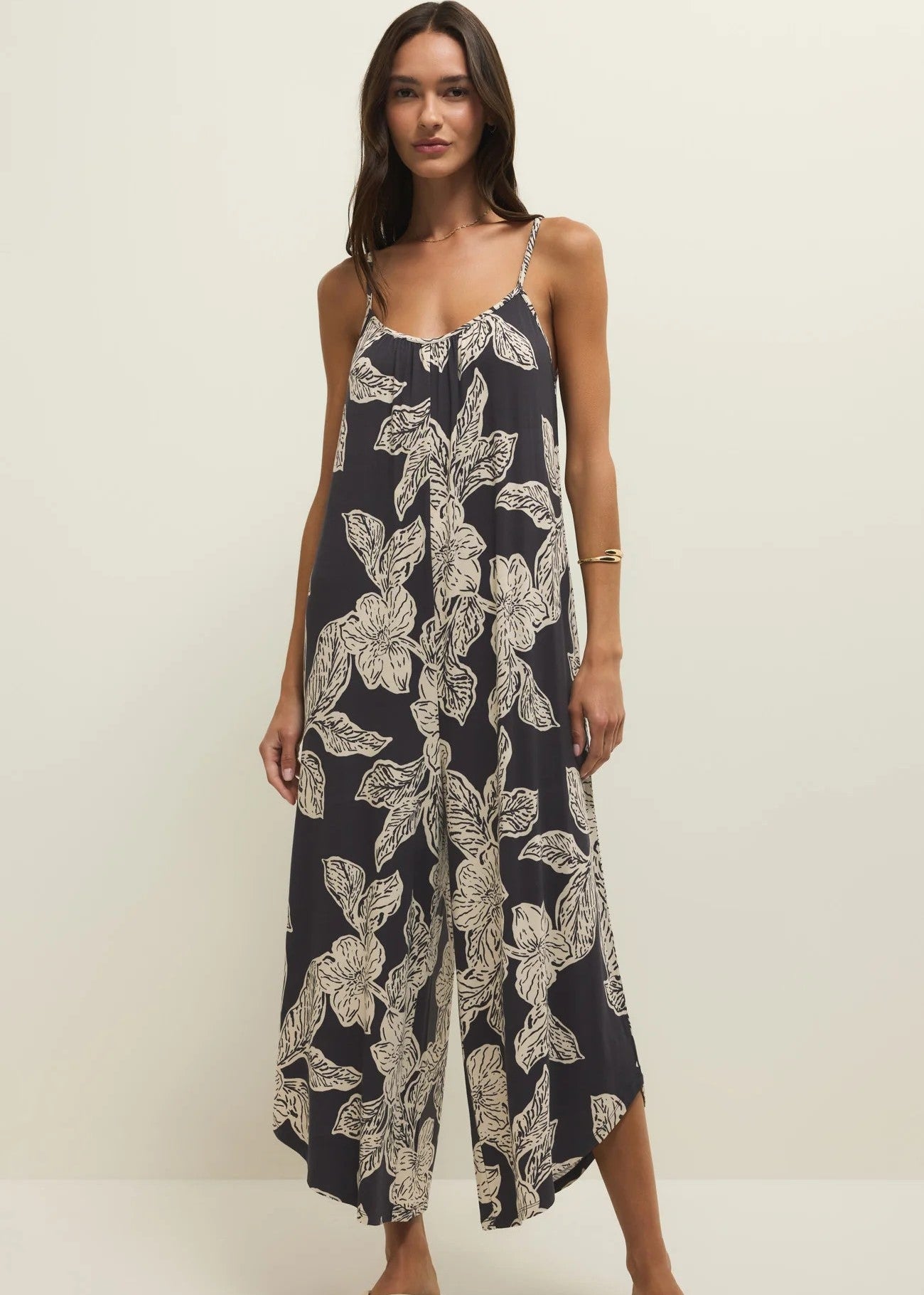 Woman wearing a navy floral jumpsuit on a white background