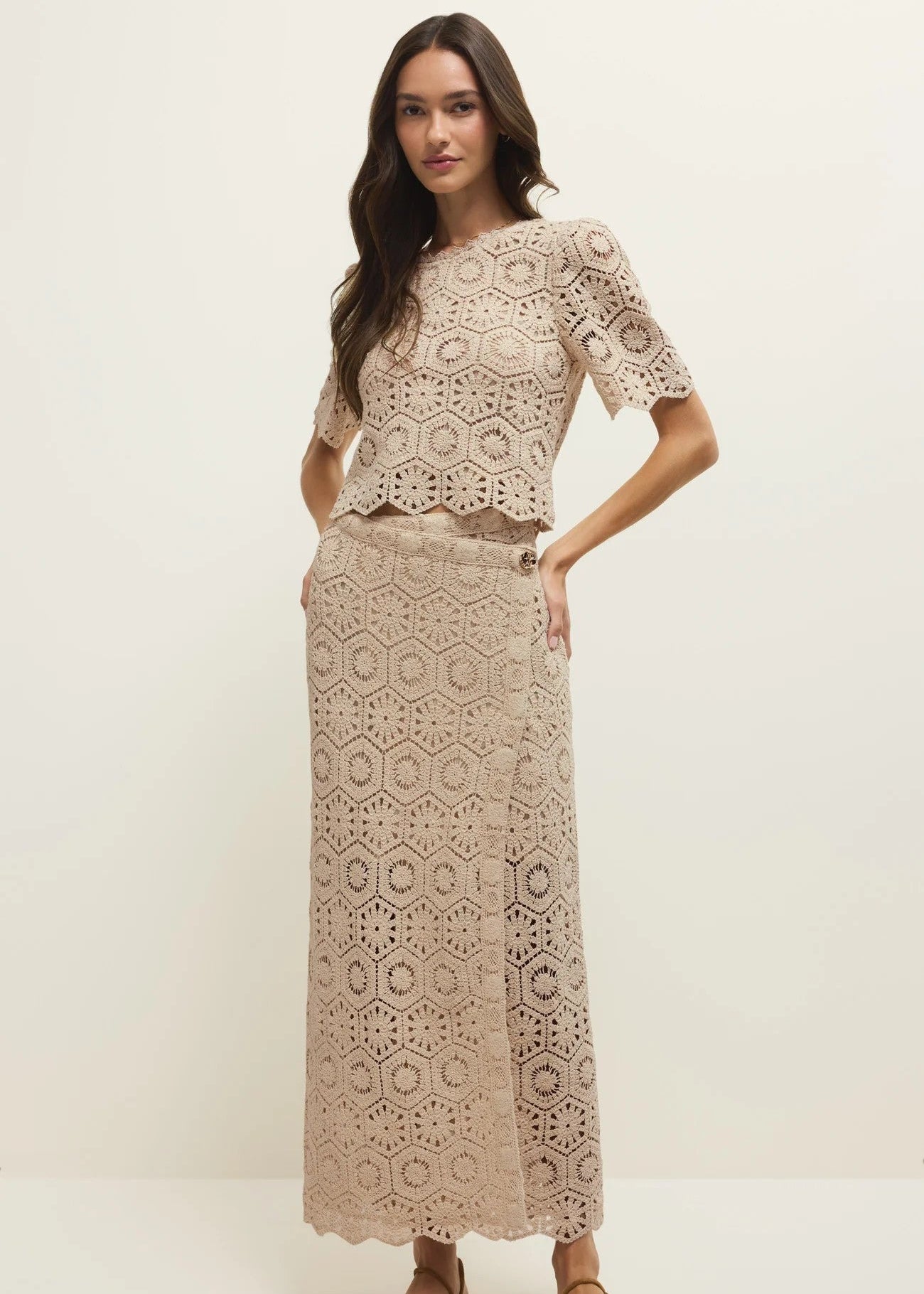 Woman wearing a beige lace outfit on a white background