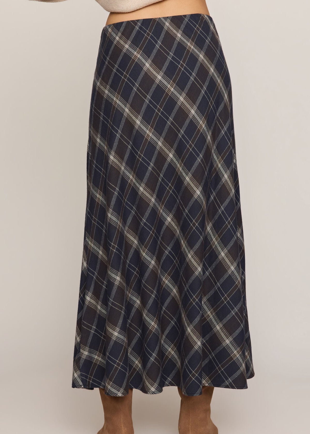 Plaid skirt worn by a person on a plain background