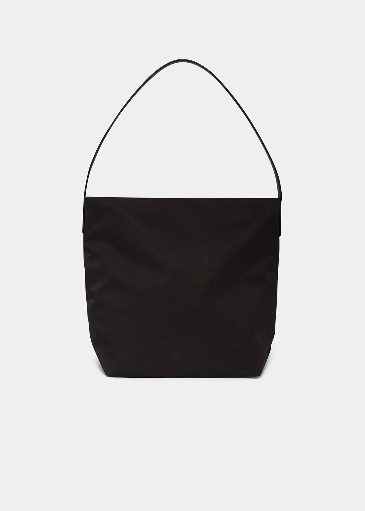A minimalist black fabric shoulder bag with a single thin strap, photographed against a solid light gray background.