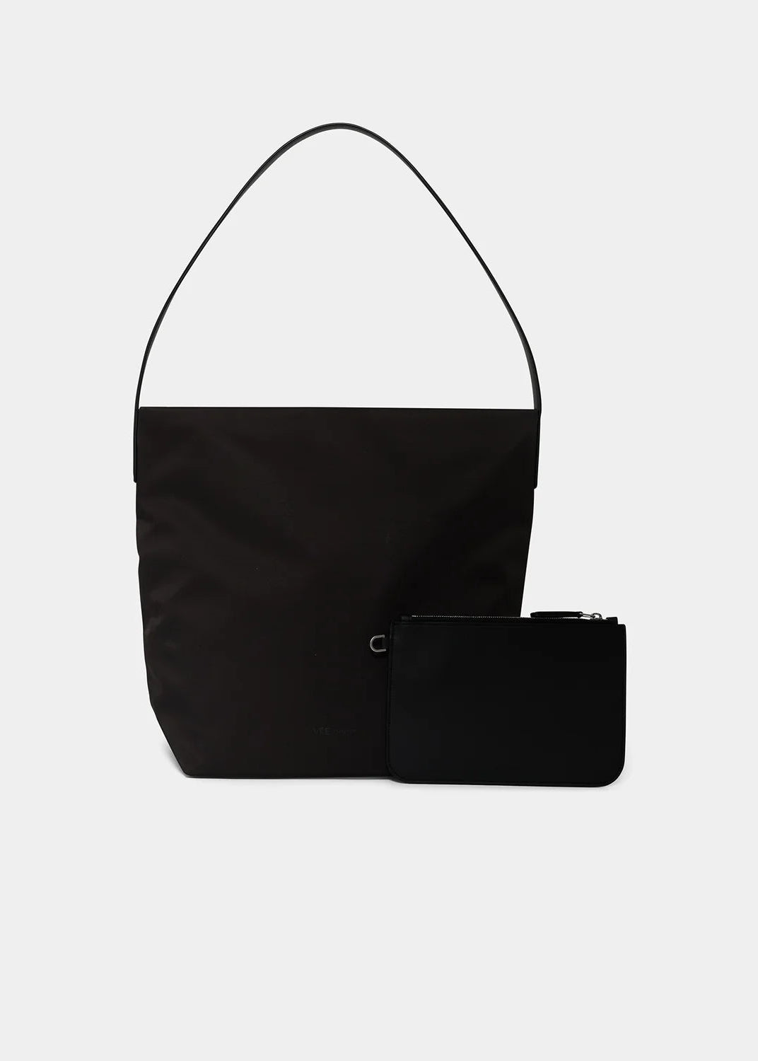 A black shoulder bag with a wide top panel and thin strap, shown with a matching black zip pouch in front on a light gray background.