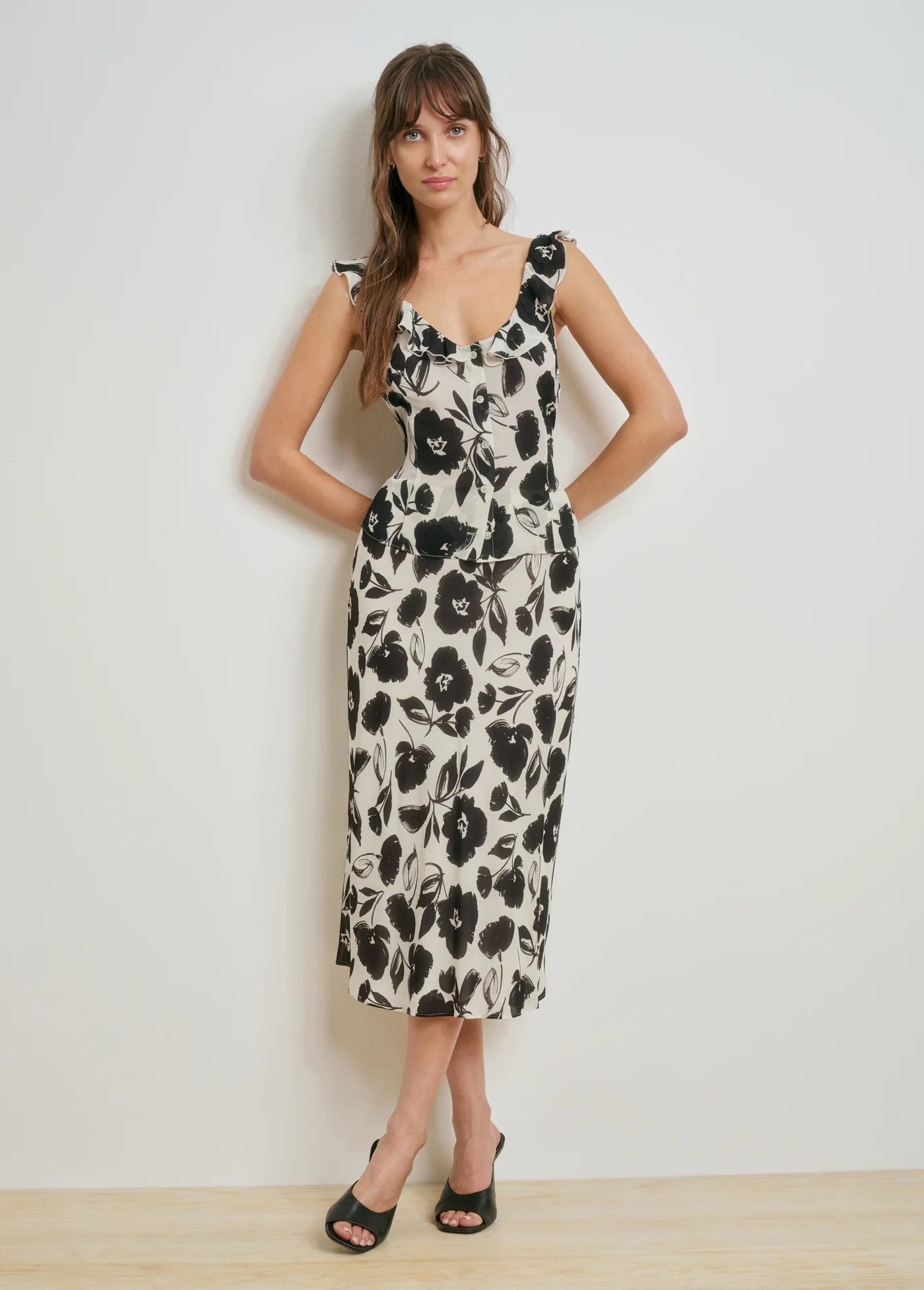 Woman wearing a black and white floral dress against a plain background