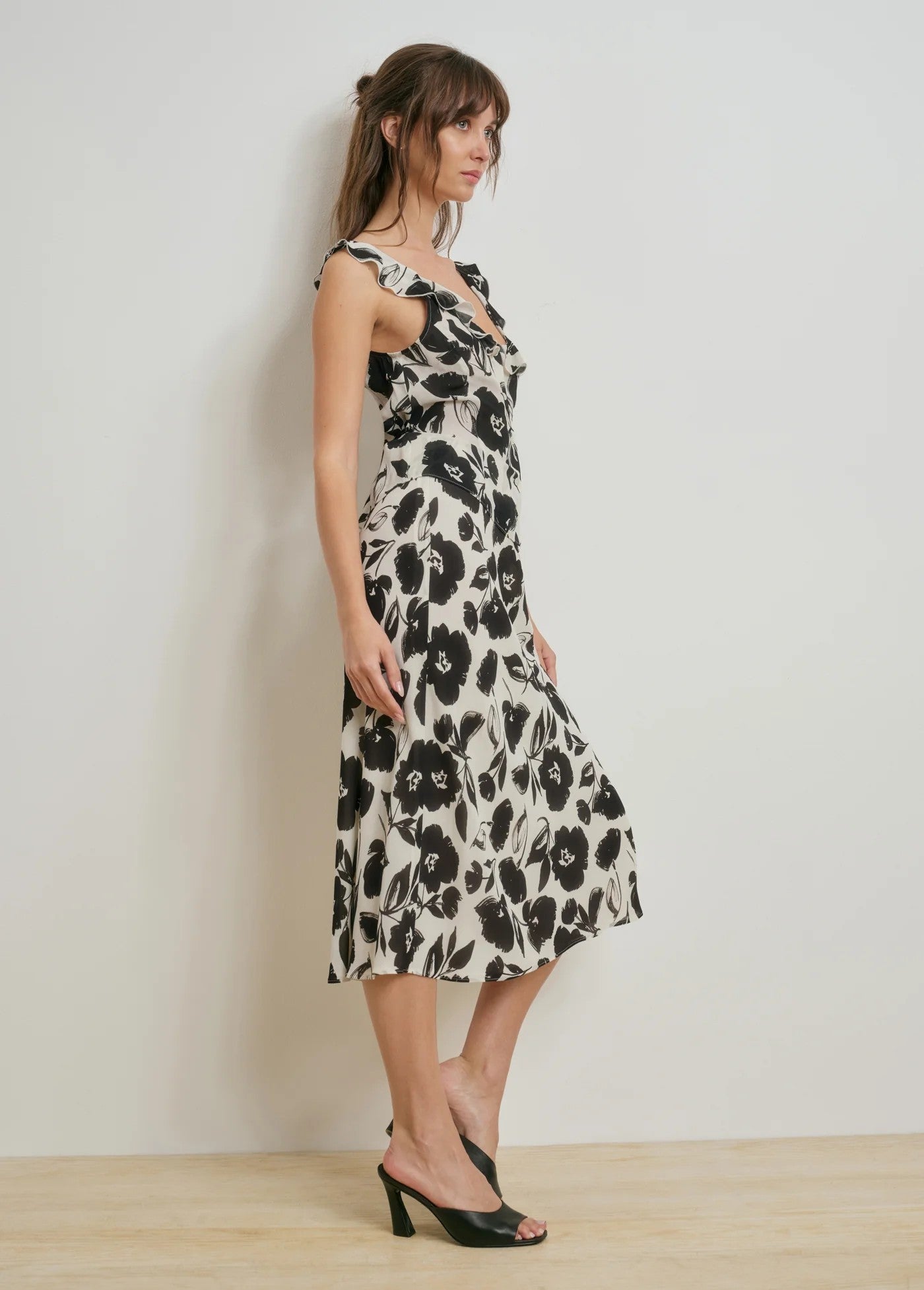 Woman wearing a black and white floral dress against a plain background