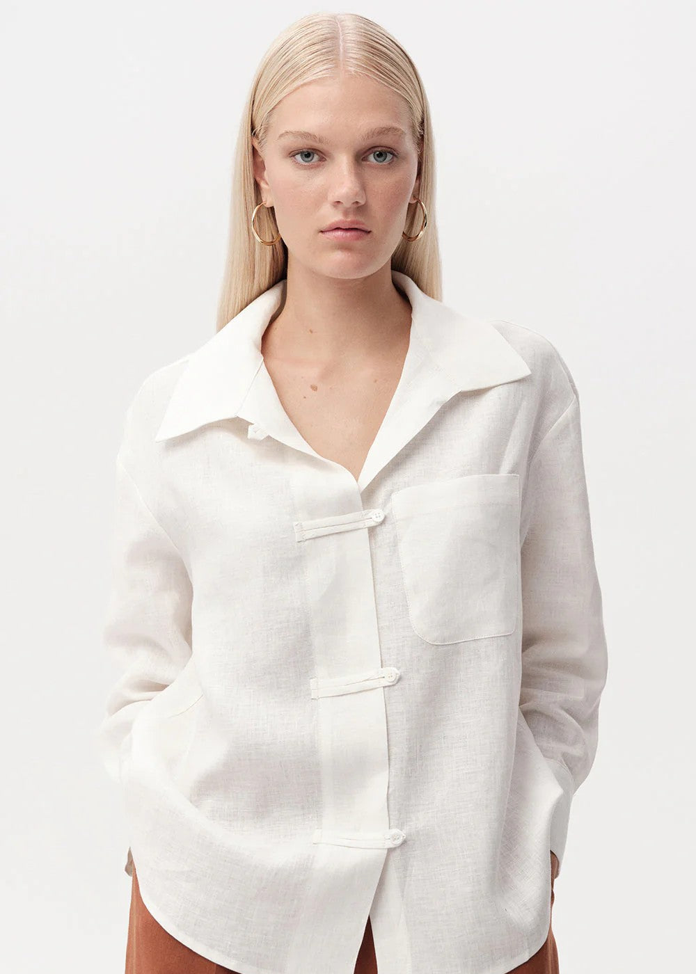 Woman wearing a white shirt with a collar on a white background