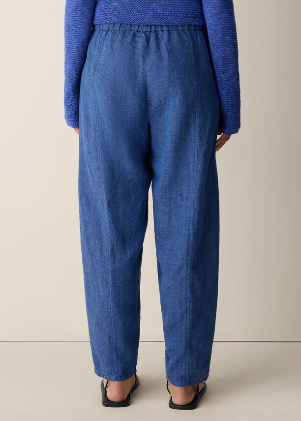 Person wearing blue pants and a blue sweater on a beige background