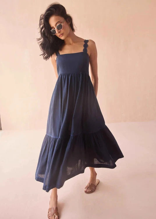 Woman wearing a navy blue dress against a beige background