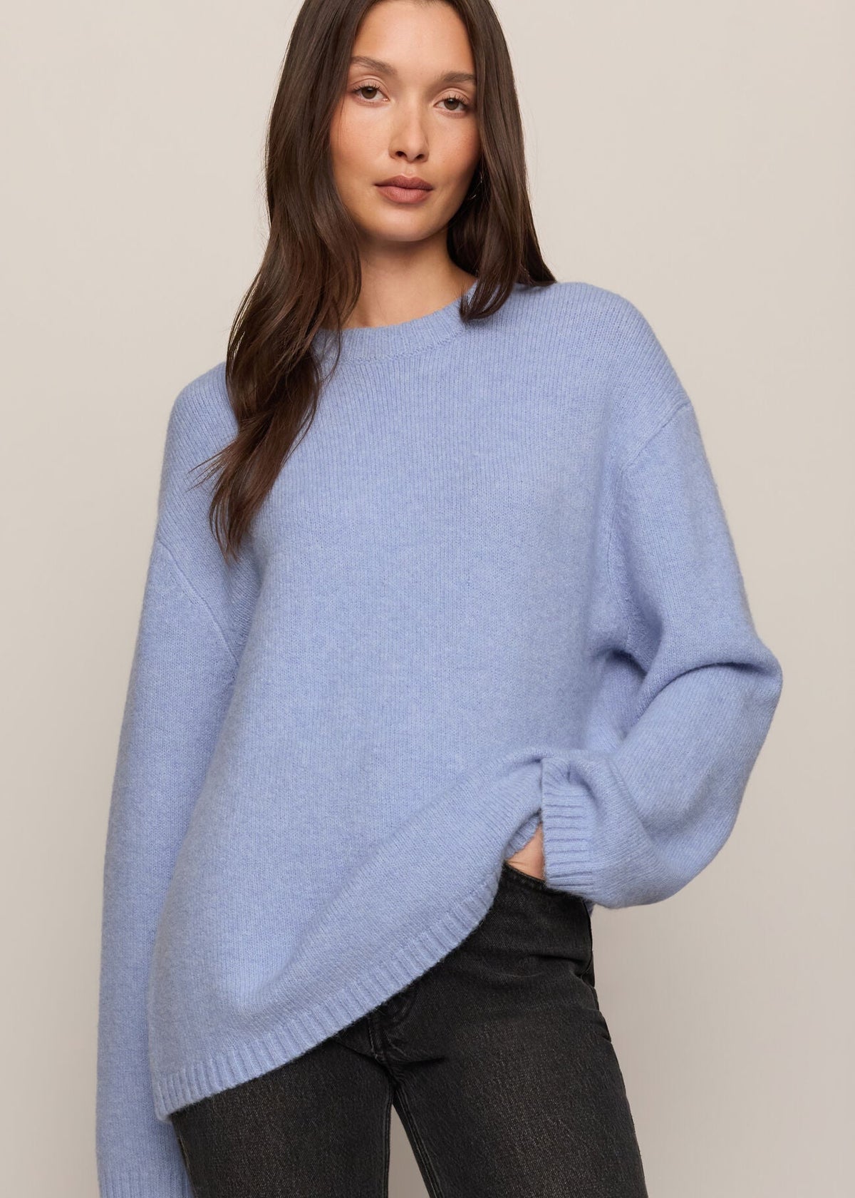 Woman wearing a light blue sweater against a beige background
