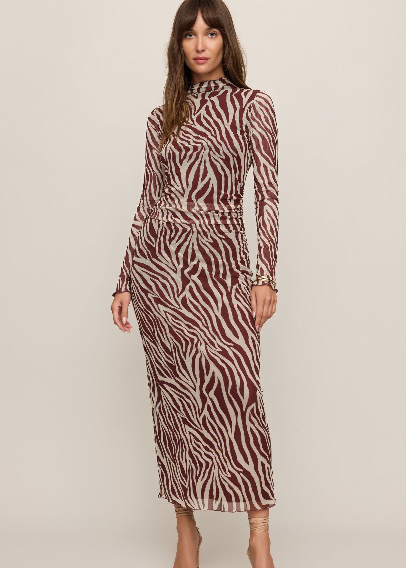 Woman wearing a zebra print dress on a plain background
