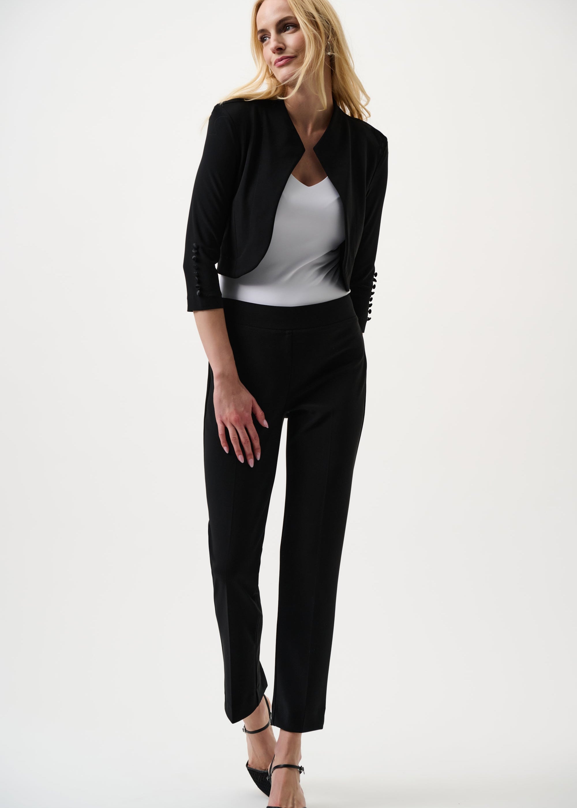 Woman wearing a black blazer and black pants on a white background