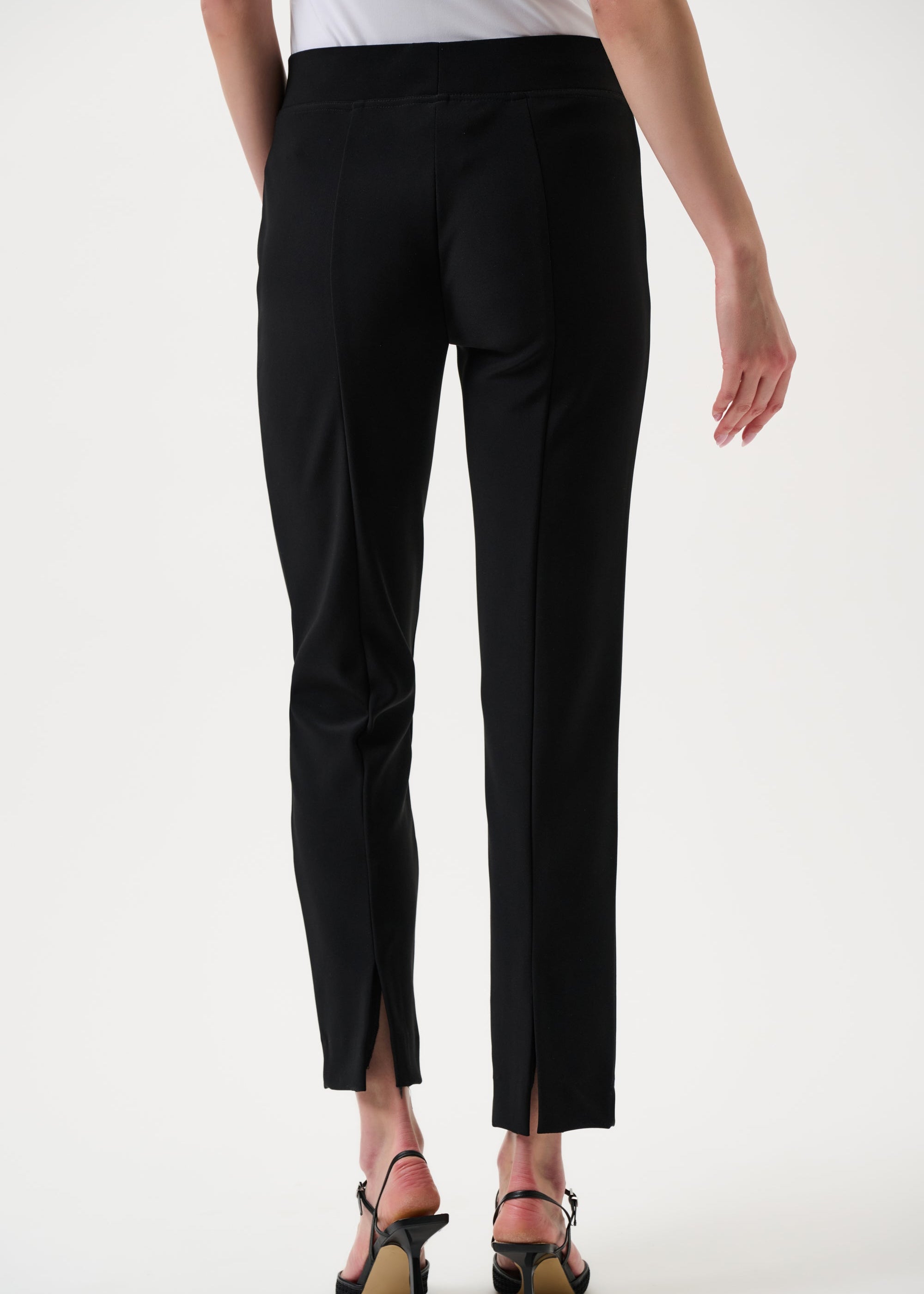 Black pants worn by a person on a white background