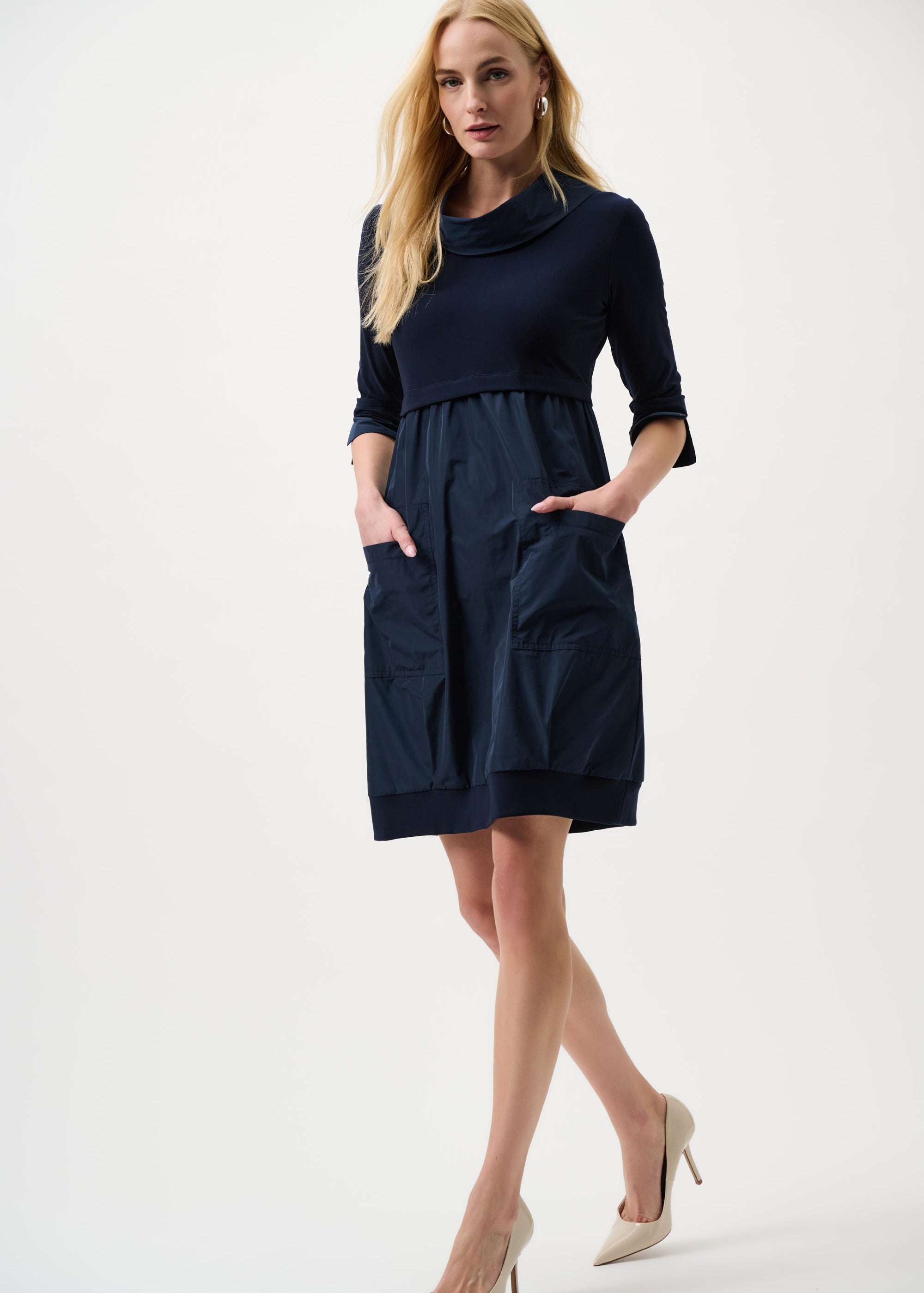 Woman wearing a navy dress on a white background