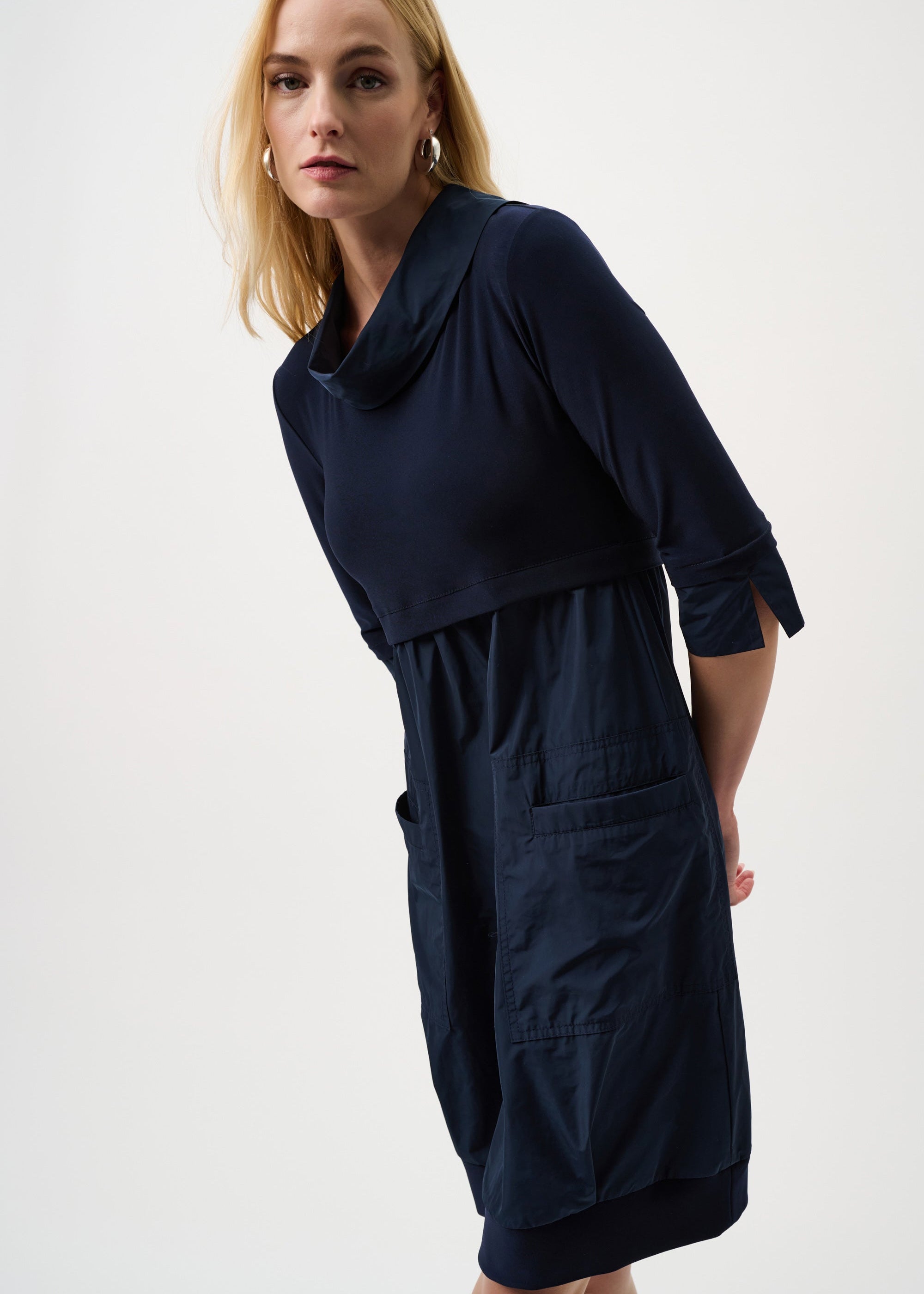 Woman wearing a navy blue dress on a white background