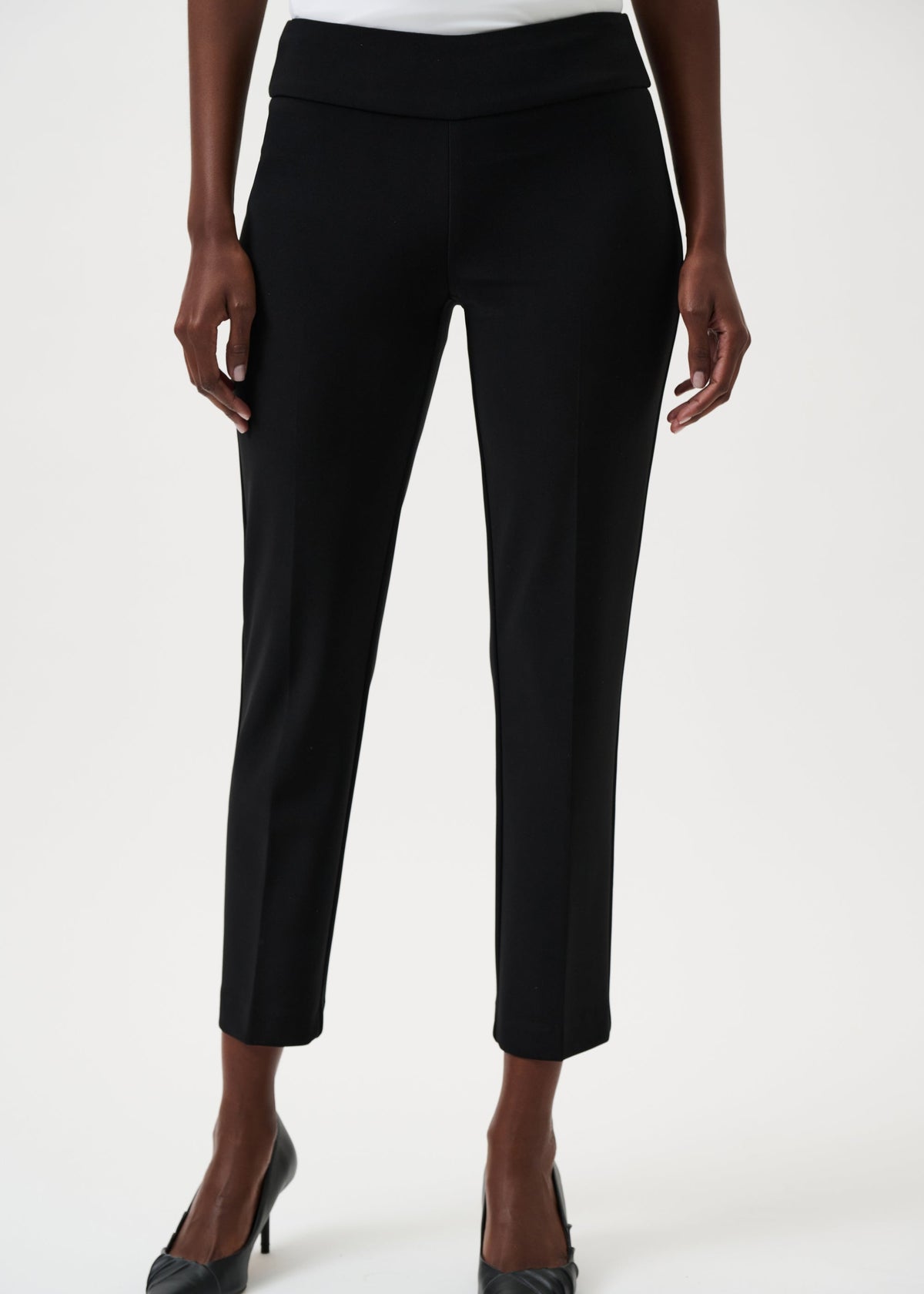 Black pants worn by a person on a white background