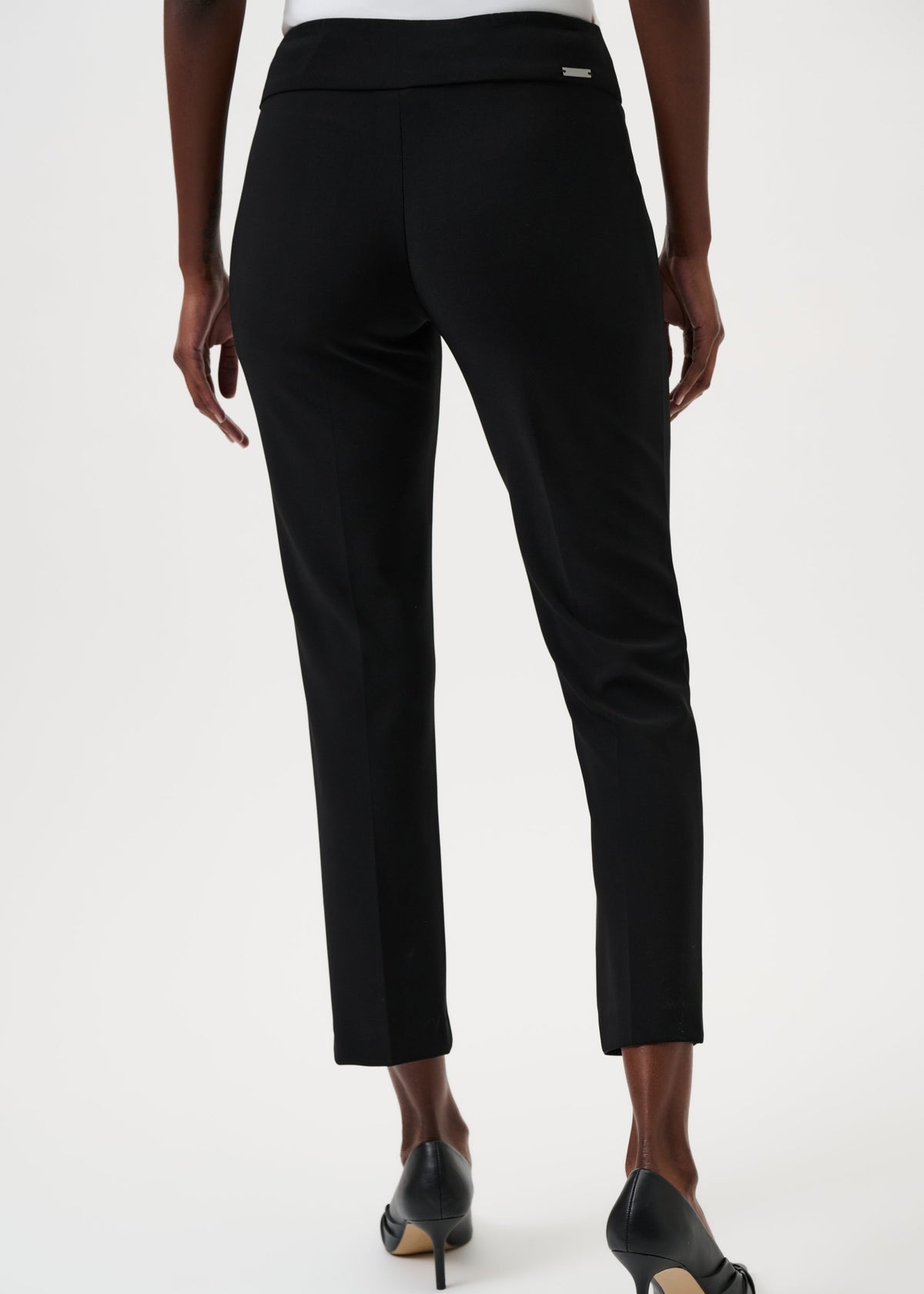 Black pants worn by a person on a white background