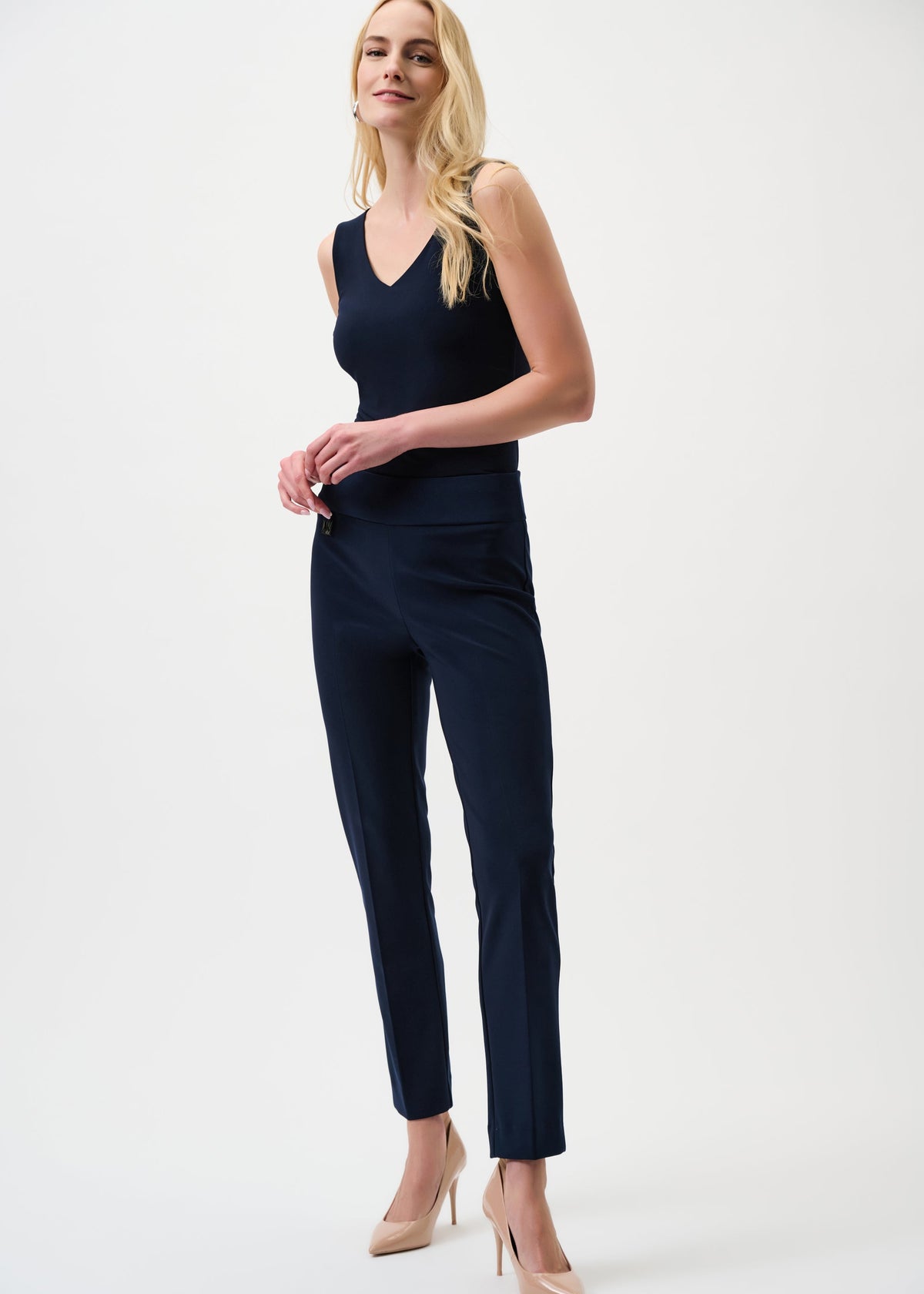 Woman wearing a navy jumpsuit on a white background