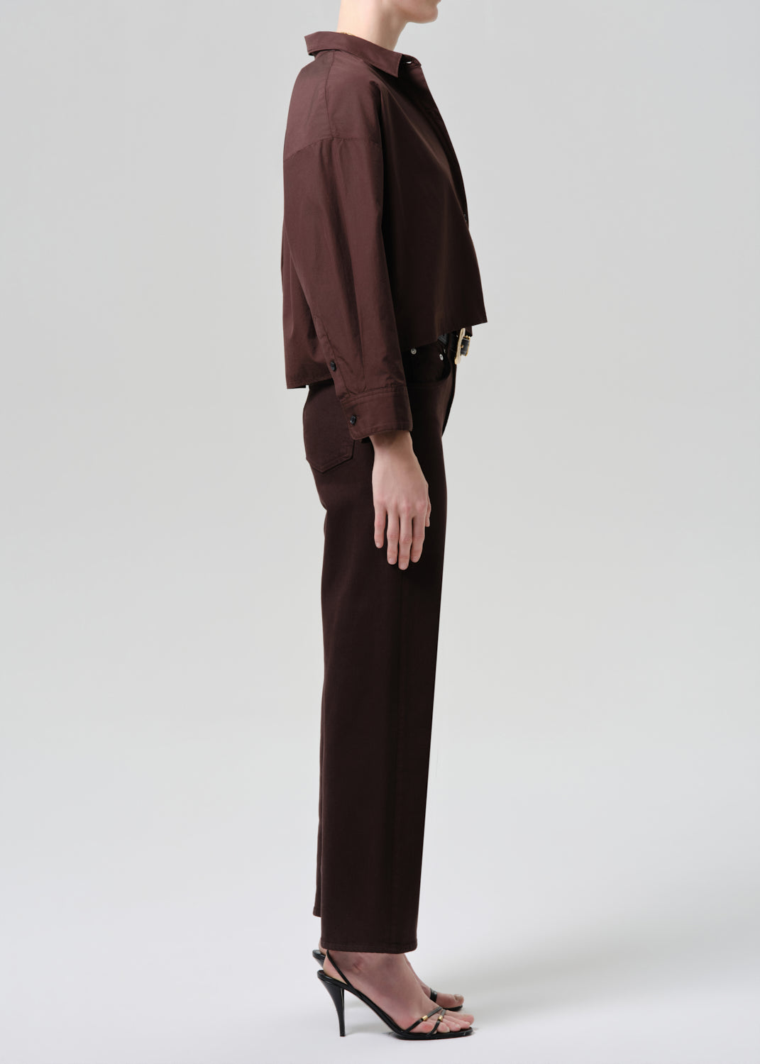 Person wearing a brown outfit on a plain background