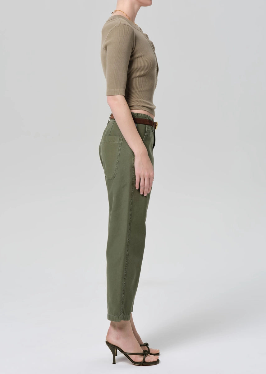 Person wearing a green top and pants on a white background