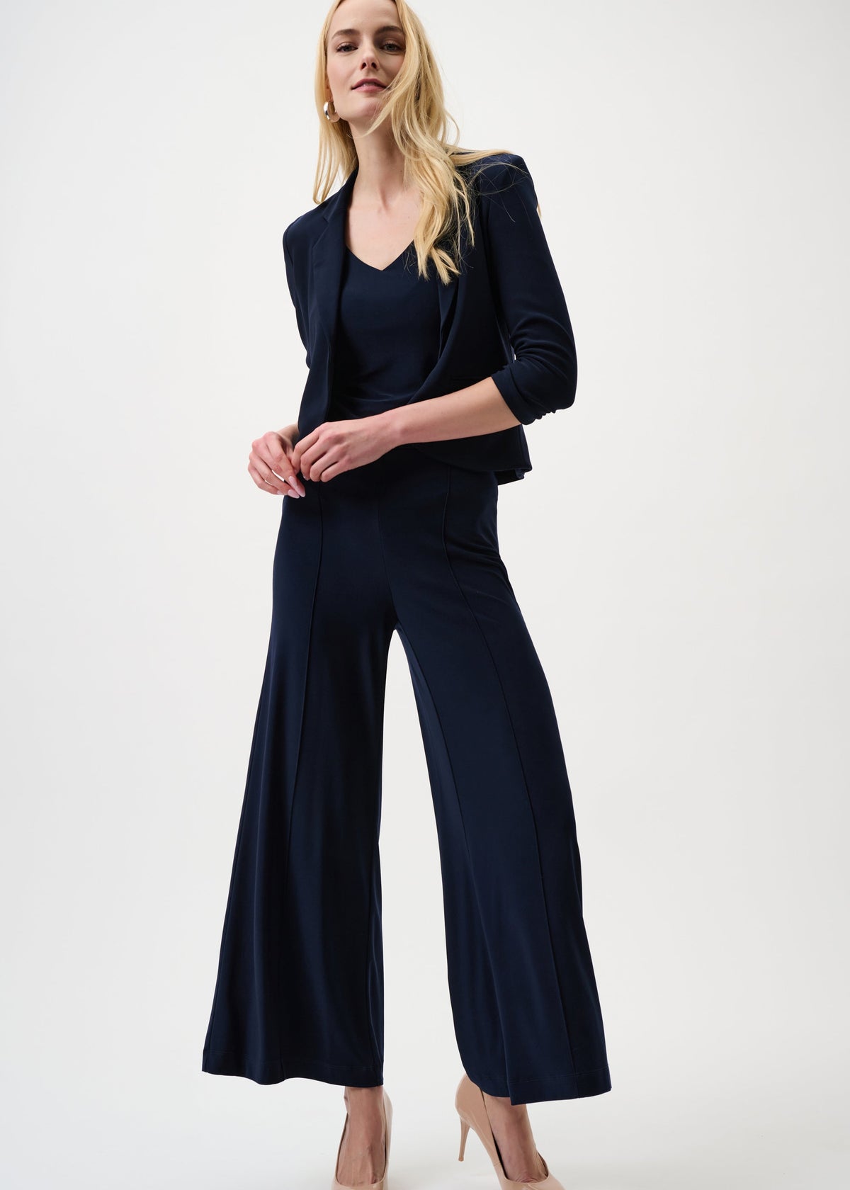 Woman wearing a navy blue outfit with wide-leg pants on a white background