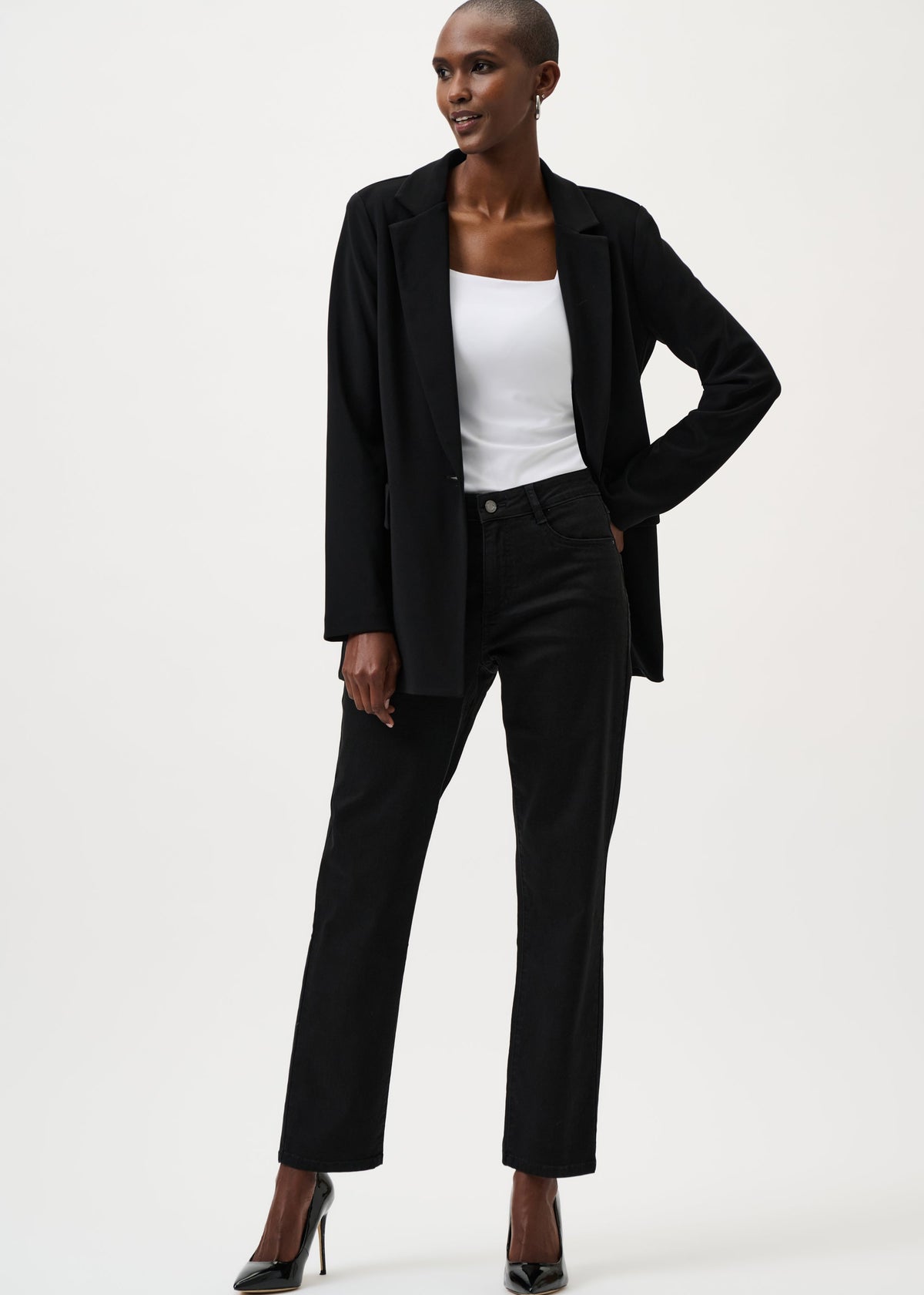 Person wearing a black suit with a white top on a white background