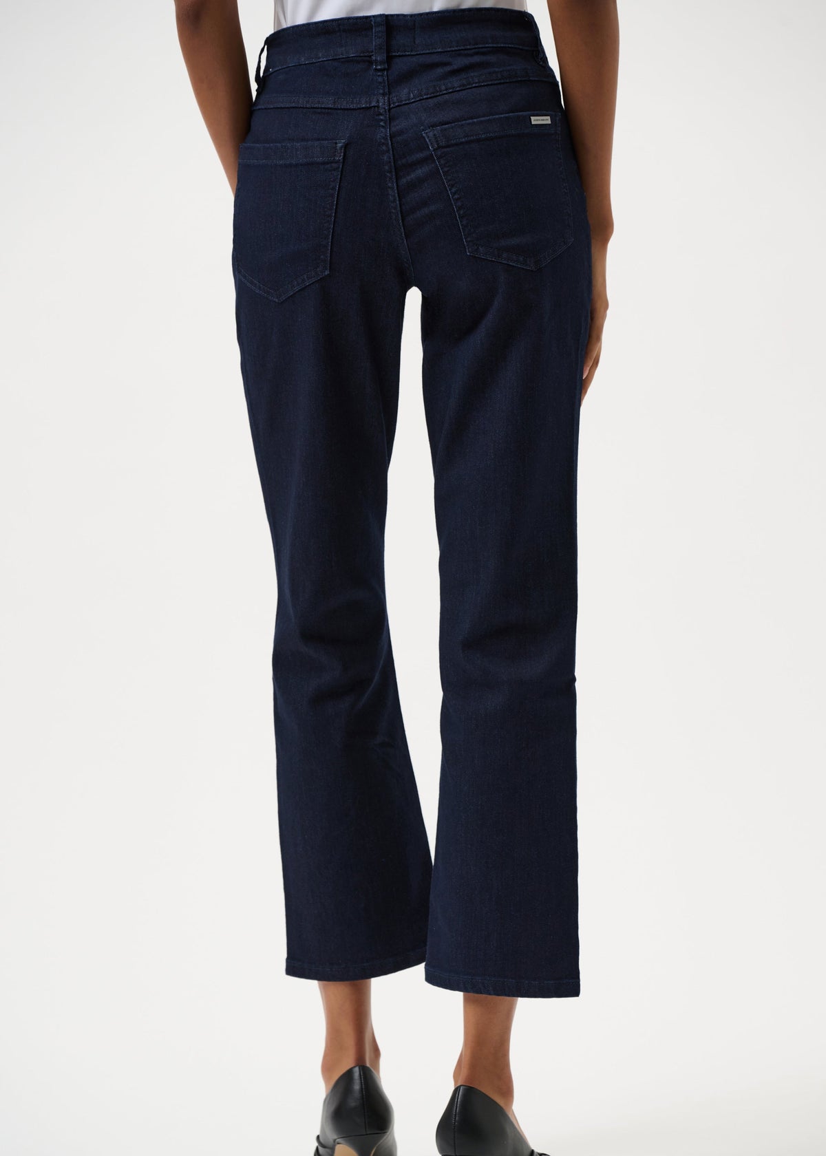 Navy blue pants worn by a person on a white background