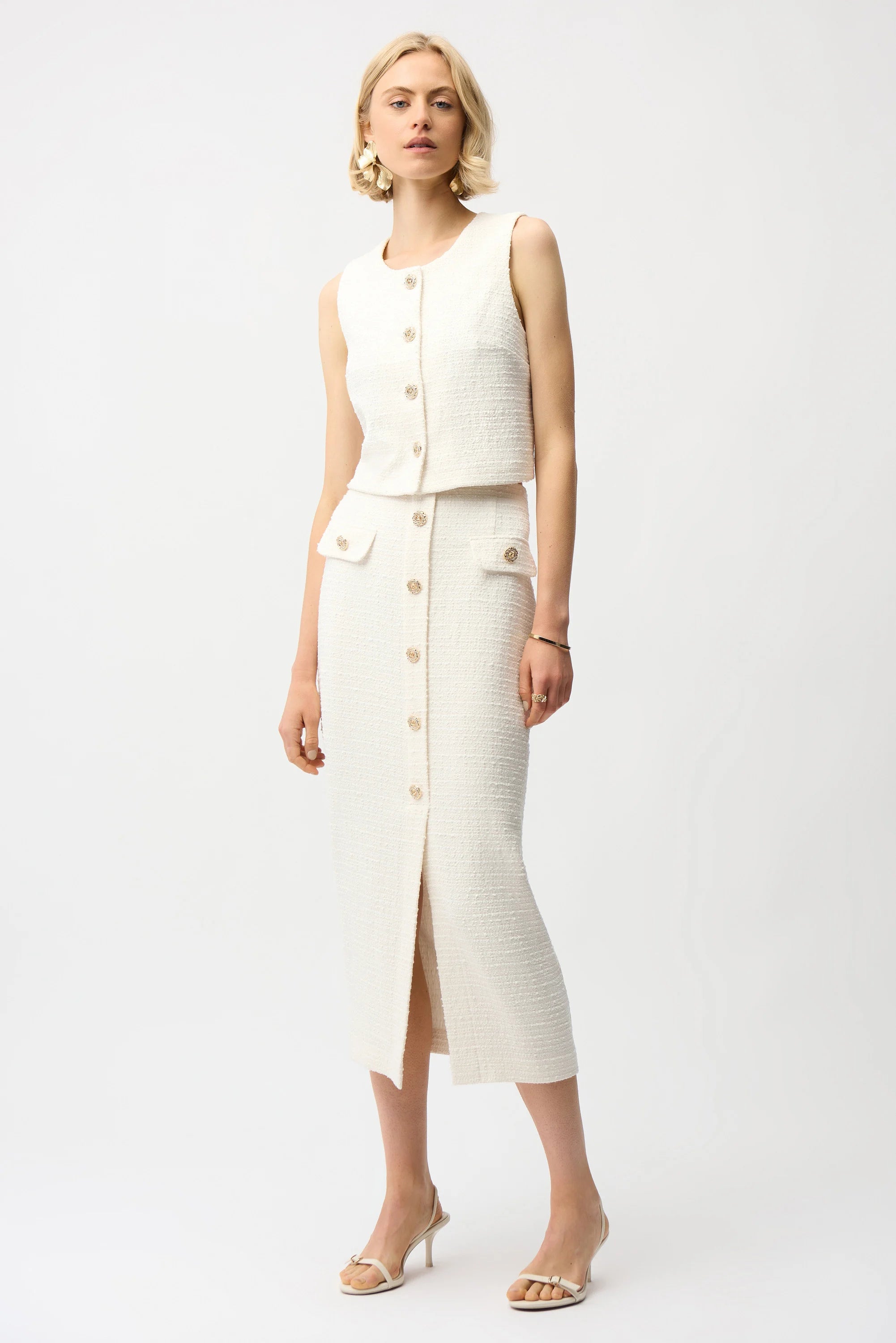 Woman wearing a white sleeveless top and skirt set on a plain background