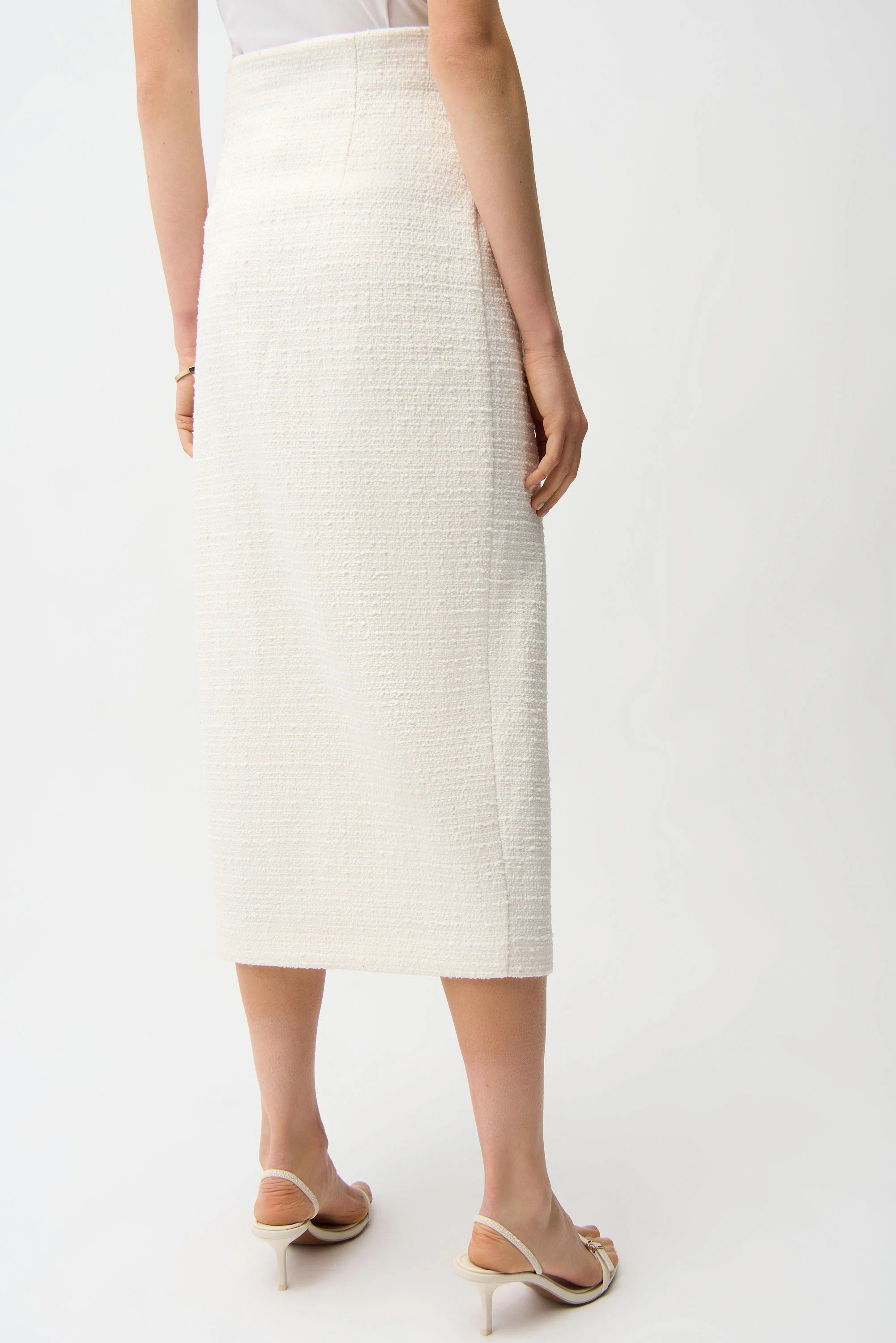 Person wearing a white textured skirt on a plain background