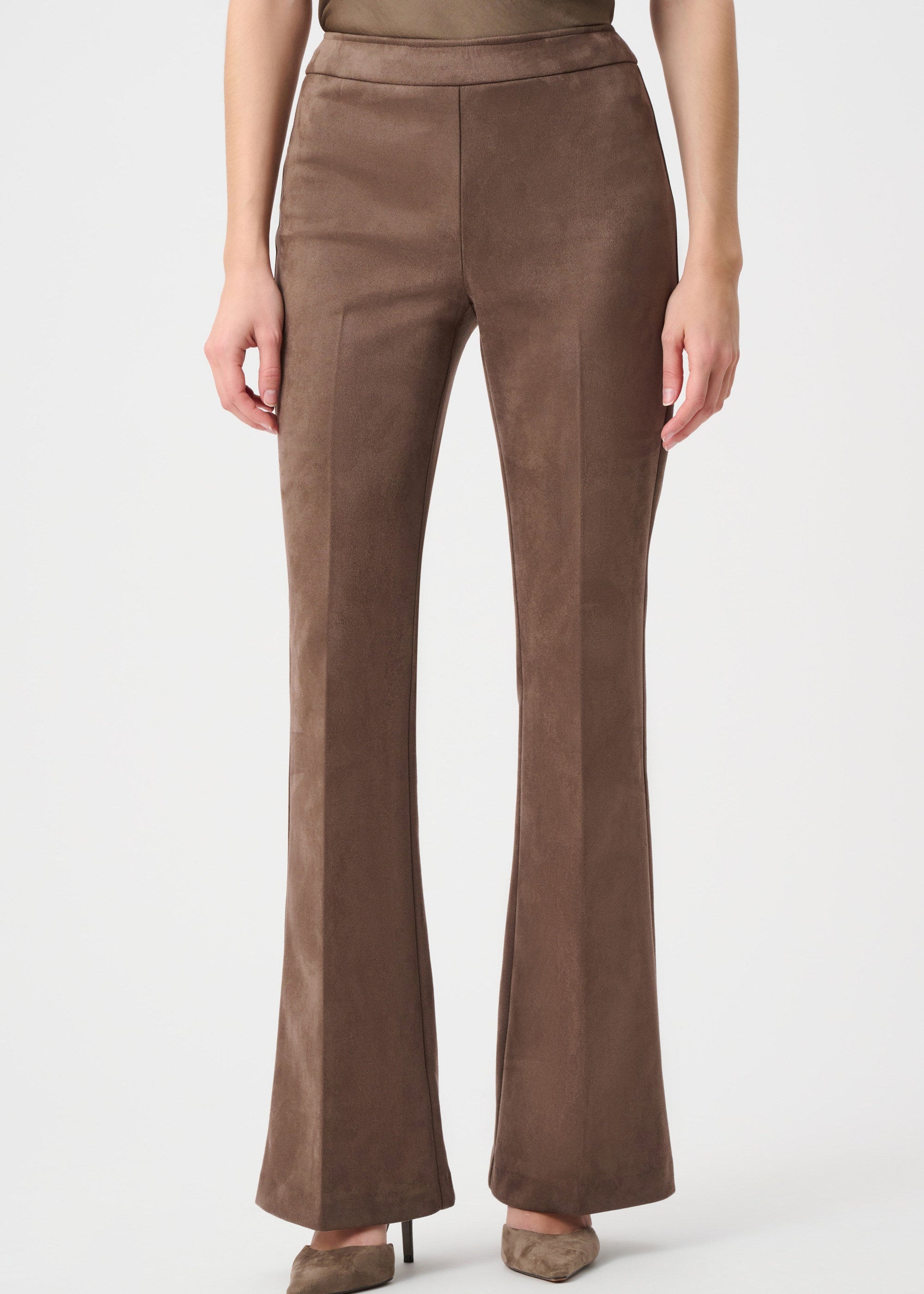 Brown flared pants worn by a person on a white background