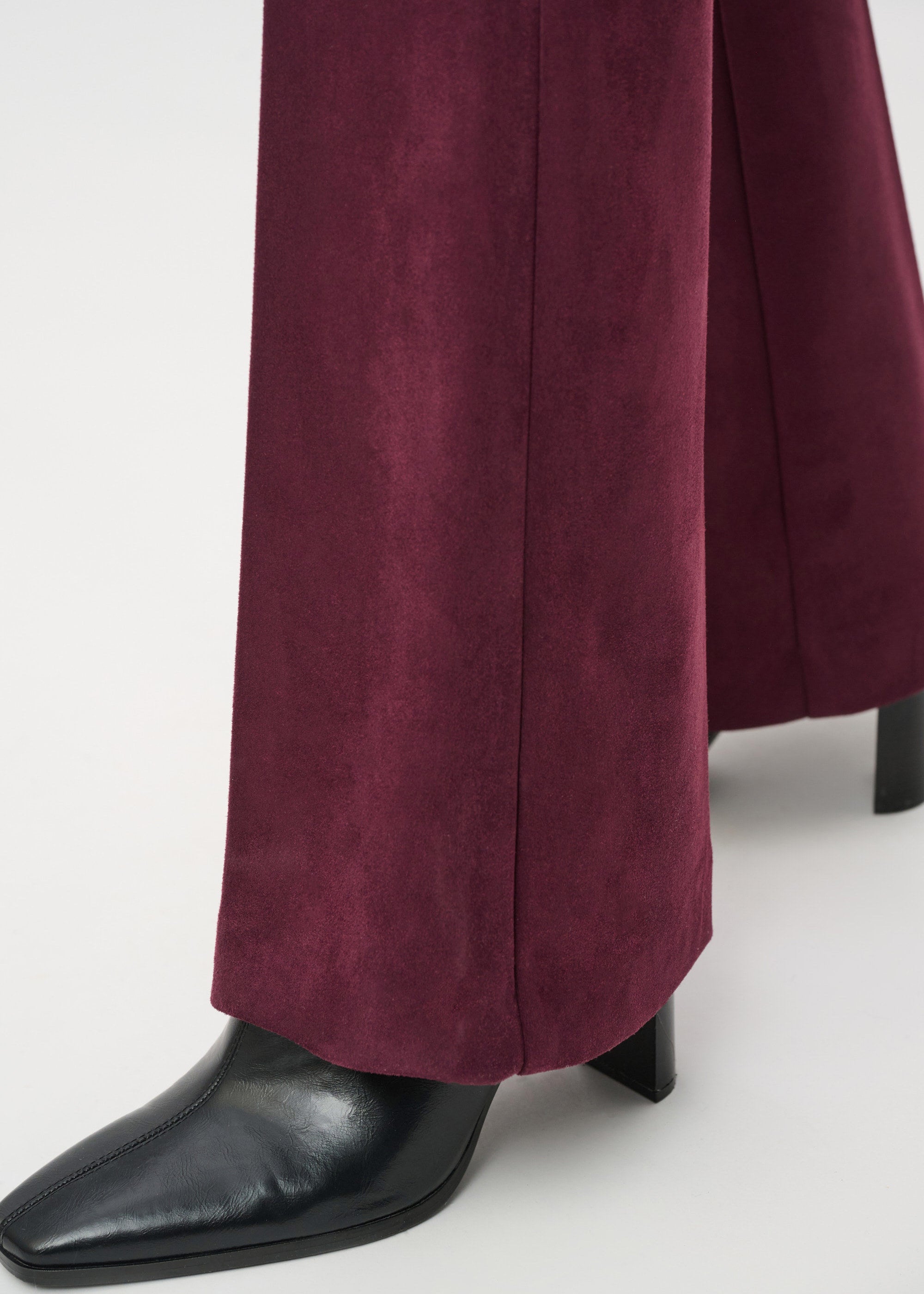 Maroon pants and black shoes on a white background