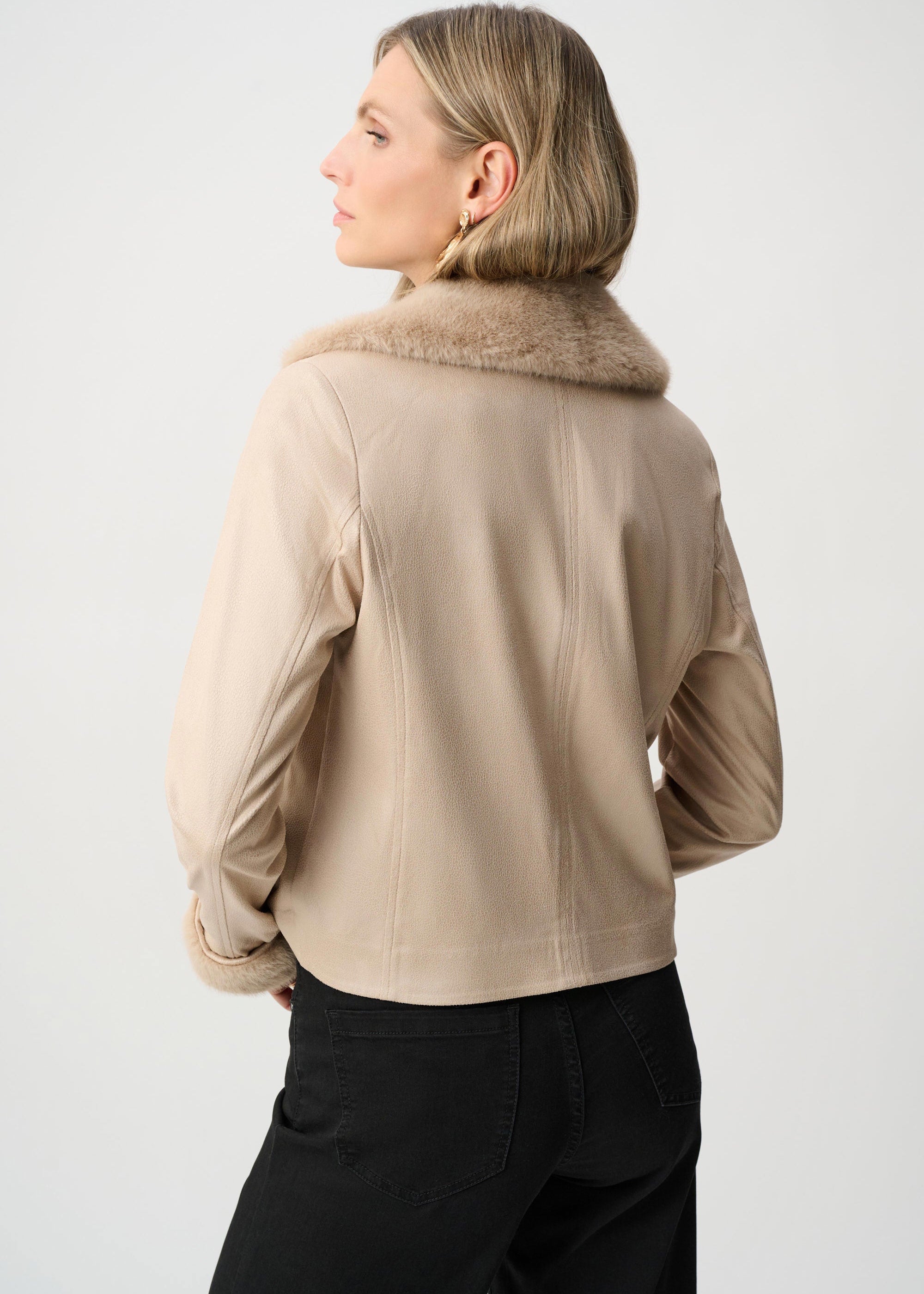 Woman wearing a beige jacket with a fur collar on a white background