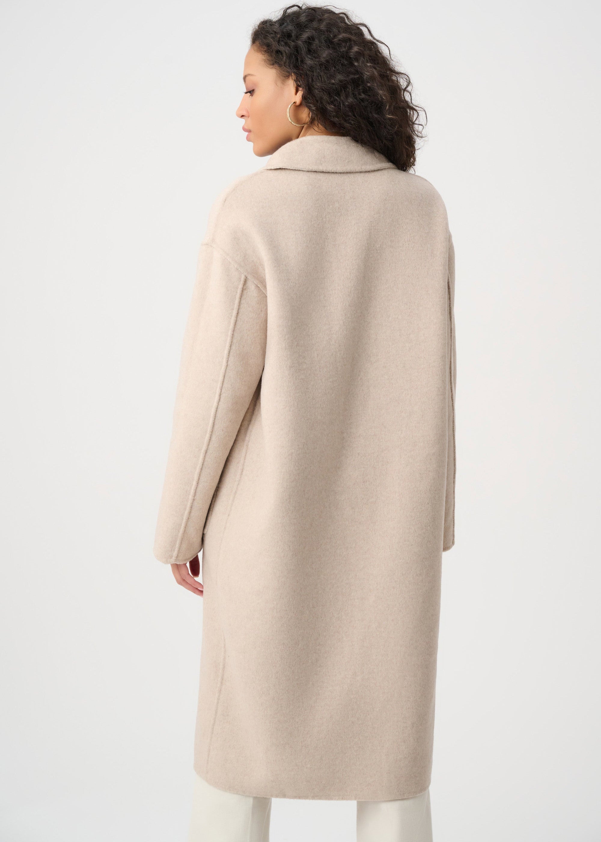 Woman wearing a beige coat on a white background