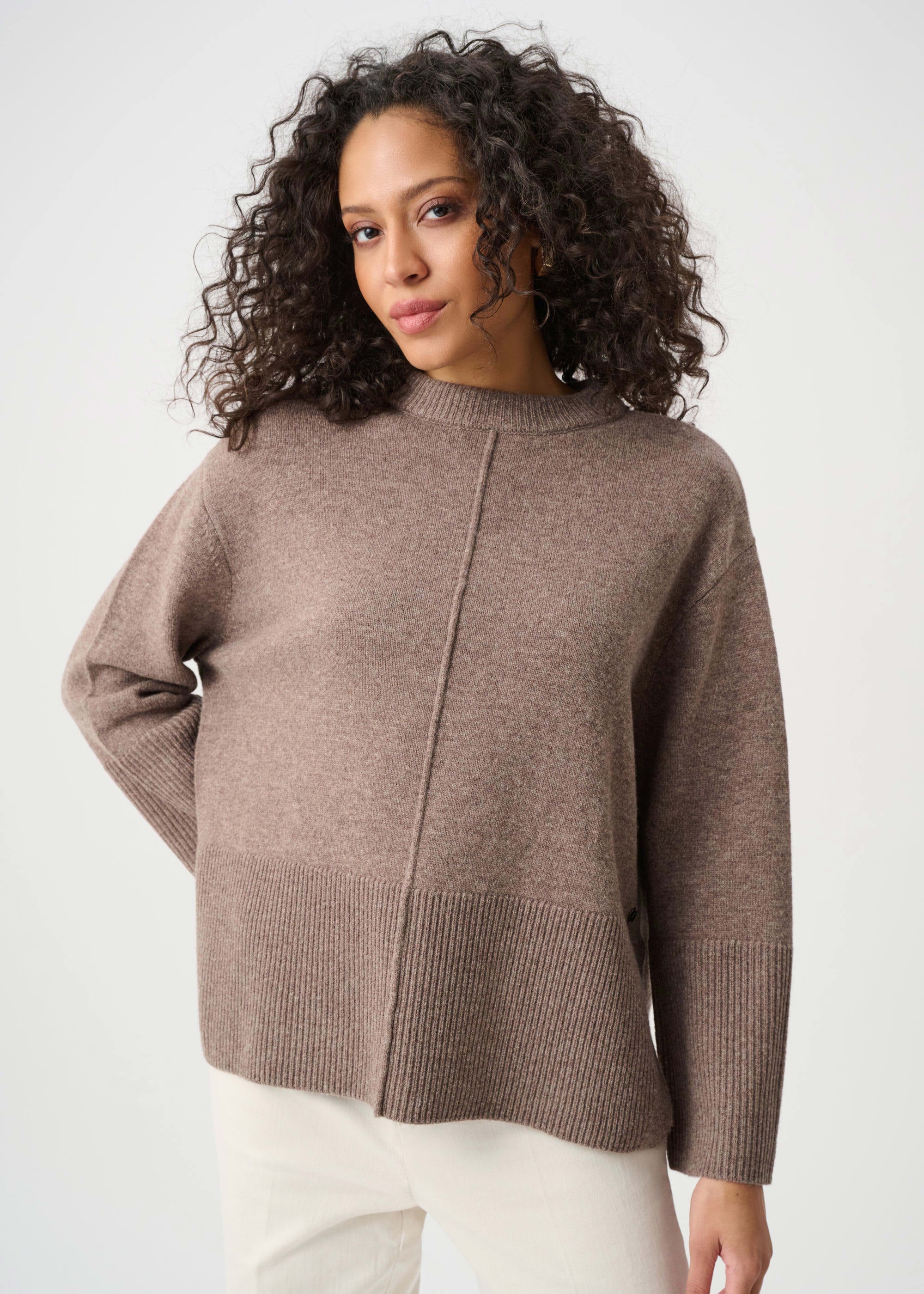 Woman wearing a brown sweater against a white background