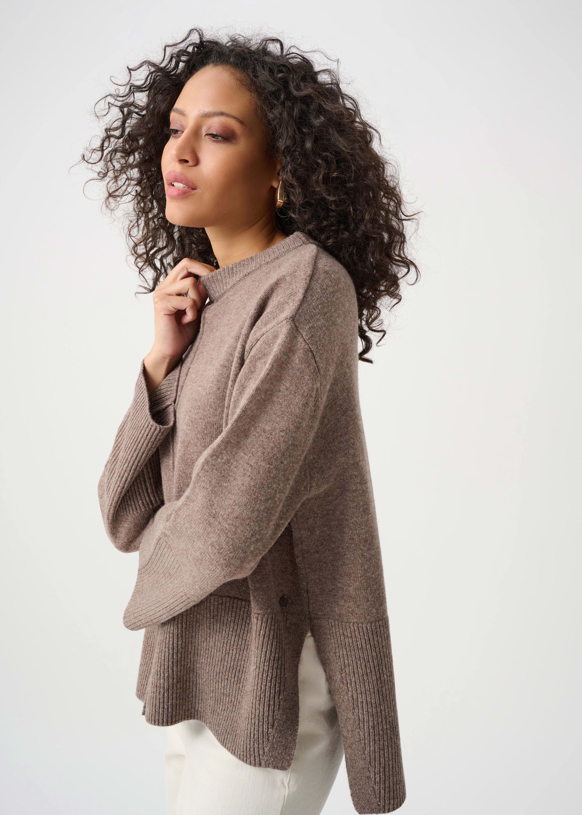 Woman wearing a brown sweater against a white background