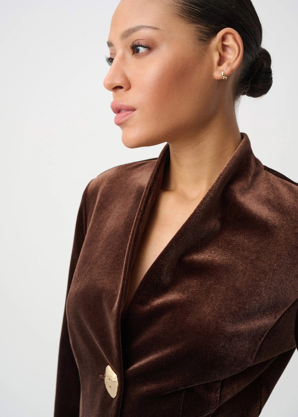 Woman wearing a brown coat against a white background