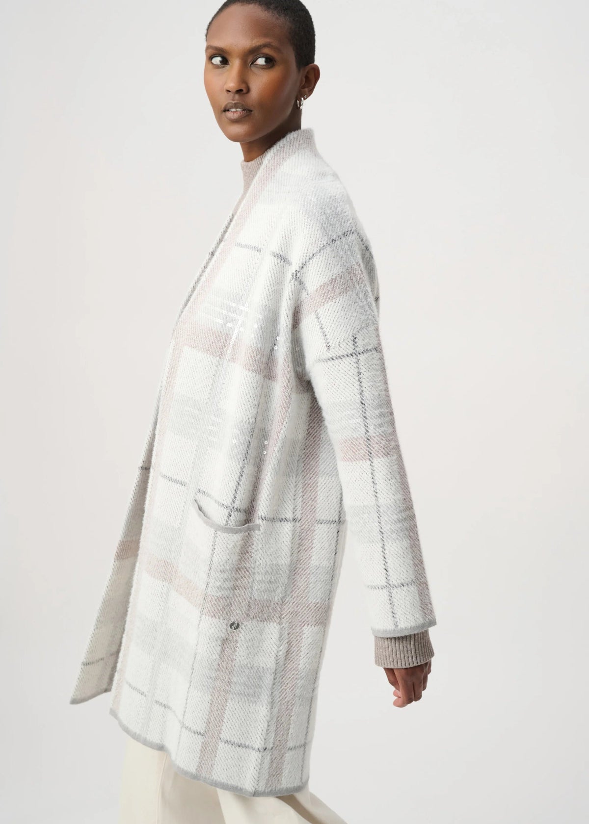 Woman wearing a light gray checkered coat on a white background