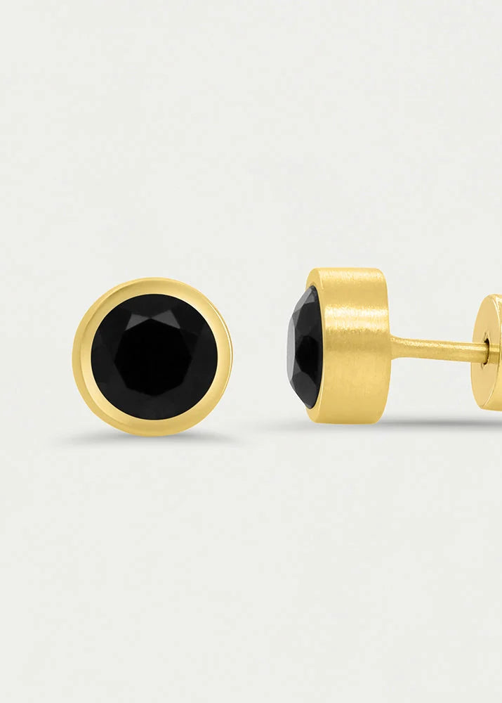 A pair of gold stud earrings with faceted black round gemstones, shown from both front and side angles on a light gray background.
