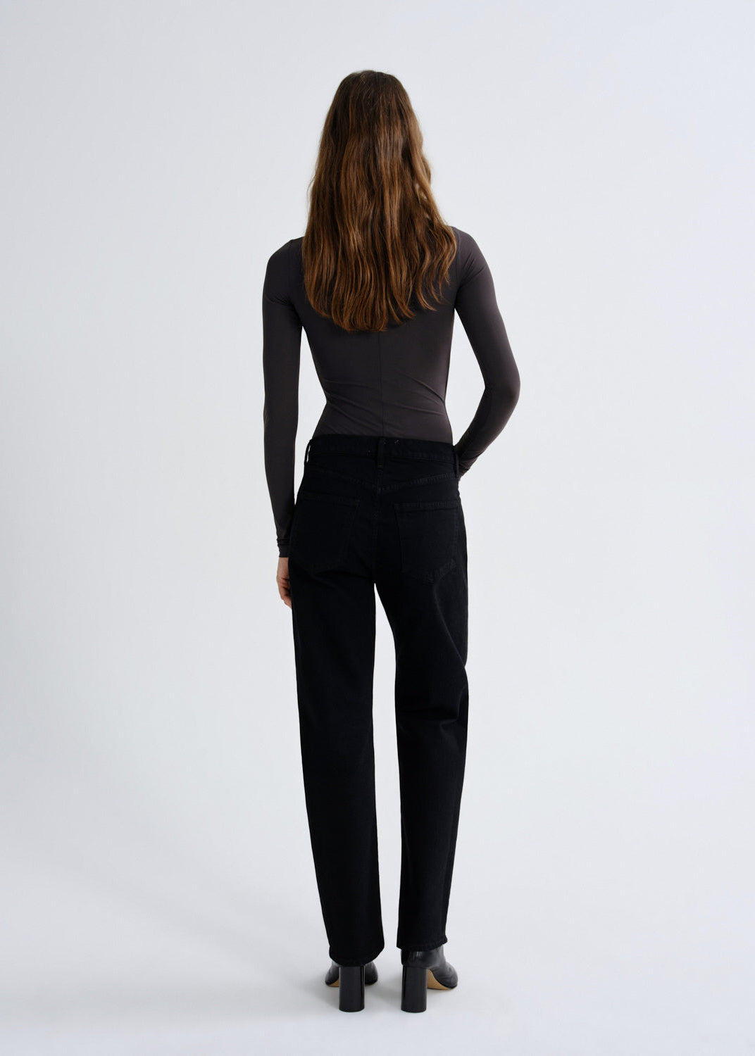 Person wearing black pants and a black top on a white background
