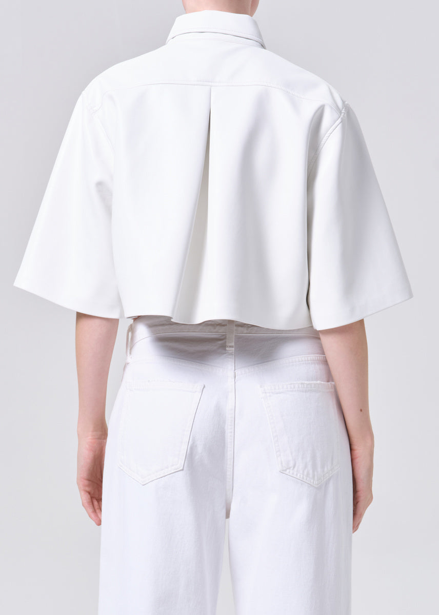 Person wearing a white shirt and pants on a plain background