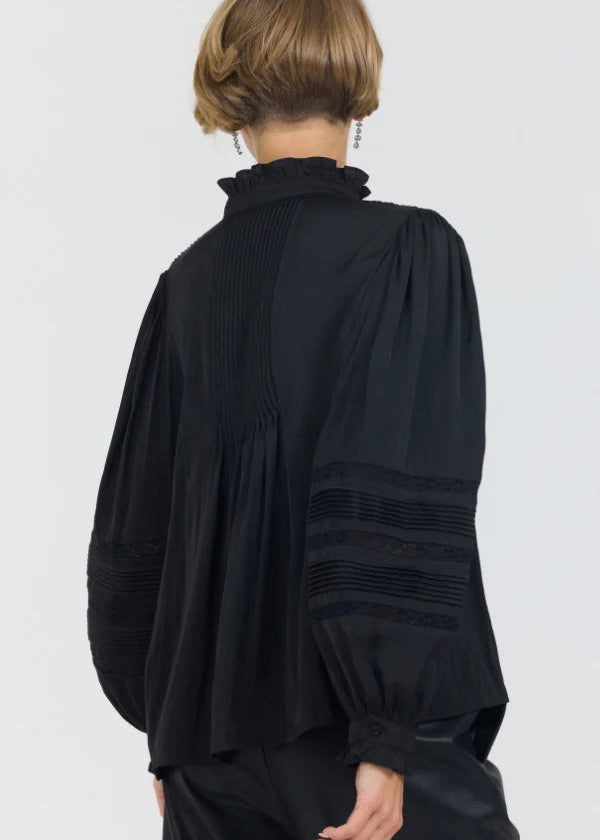 Black blouse with long sleeves and pleated details on a white background