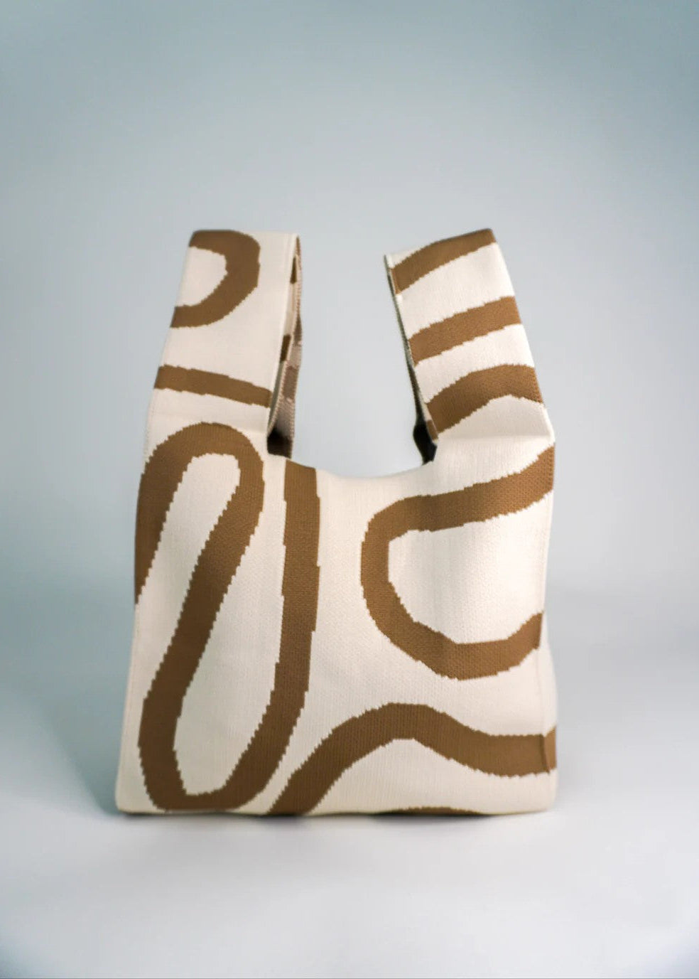 Tote bag with brown abstract patterns on a light gray background