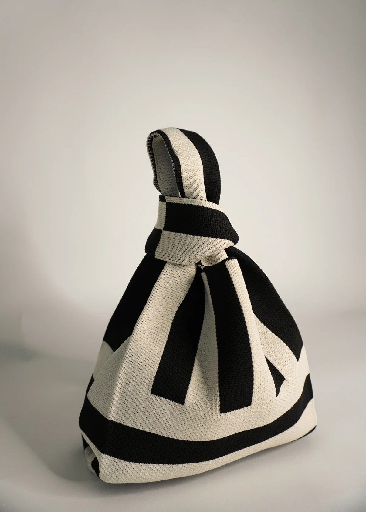 Black and white knitted bag on a gray background
