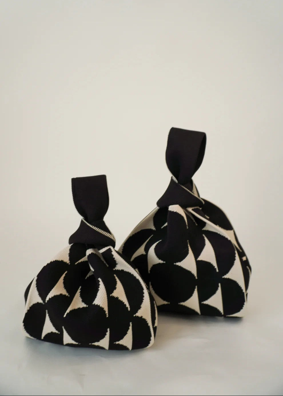 Two black and white patterned fabric bags on a light gray background