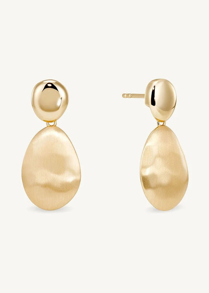 A pair of gold drop earrings with a textured teardrop-shaped pendant and a smooth round stud, shown on a light cream background.