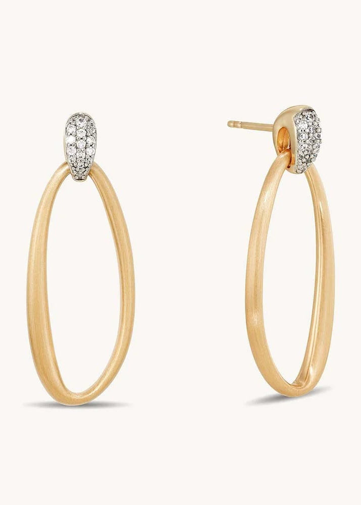 A pair of gold hoop earrings with a pavé-set oval clear stone at the top, shown on a clean off-white background.