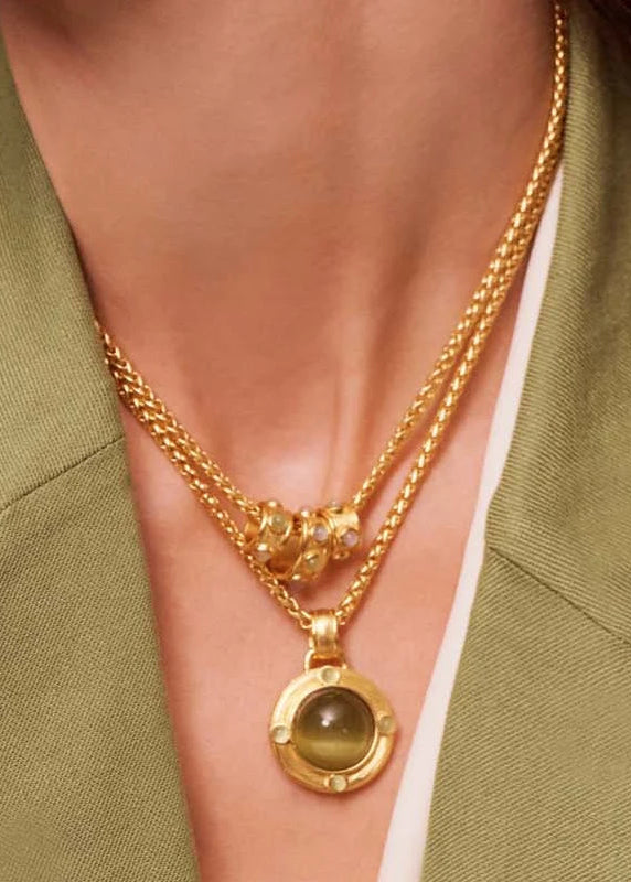 woman wearing green and gold necklace