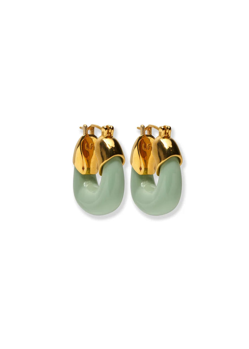 A pair of gold hoop earrings with light green curved inlay details, displayed on a clean white background.