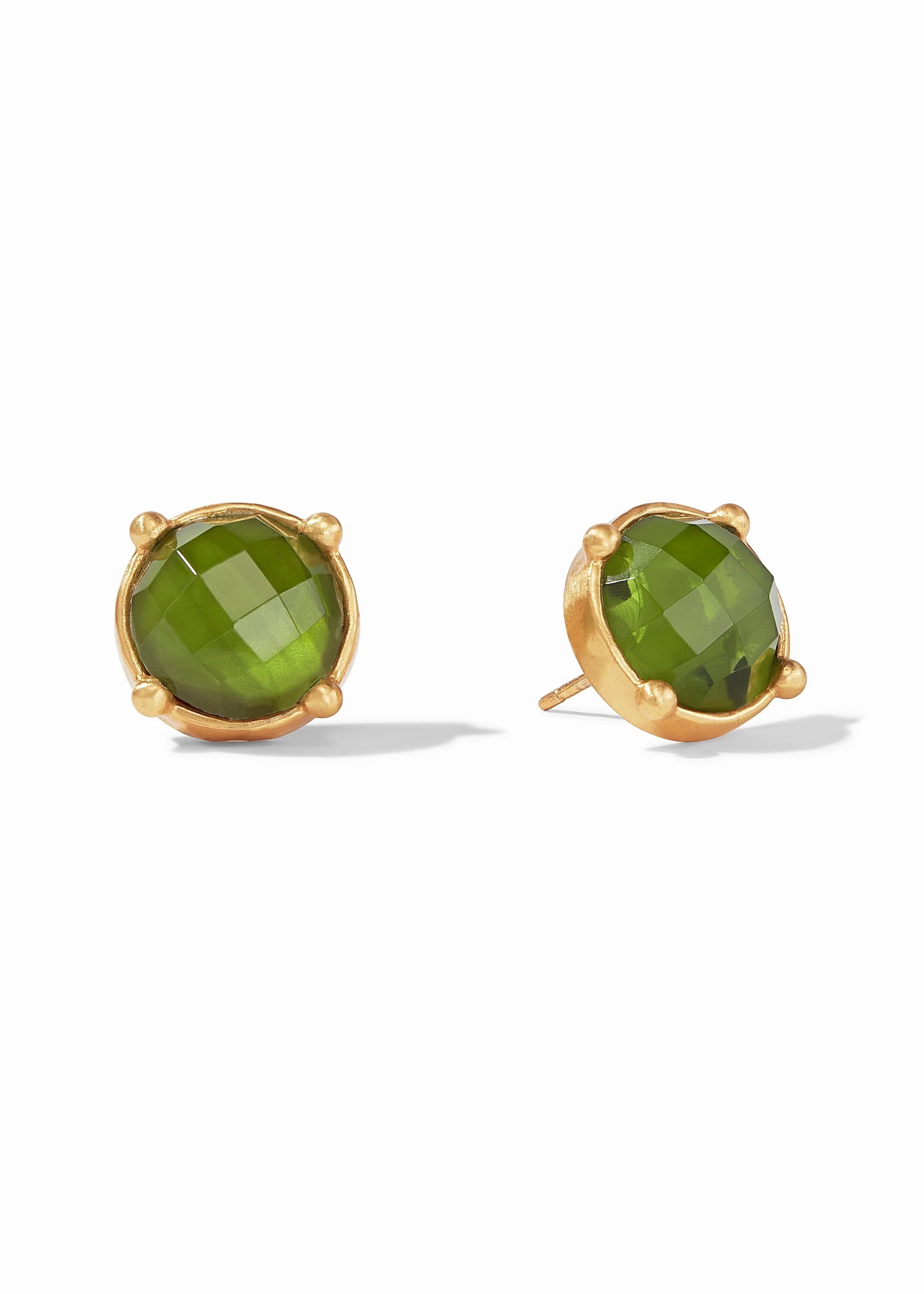 Gold earrings with green gemstones on a white background