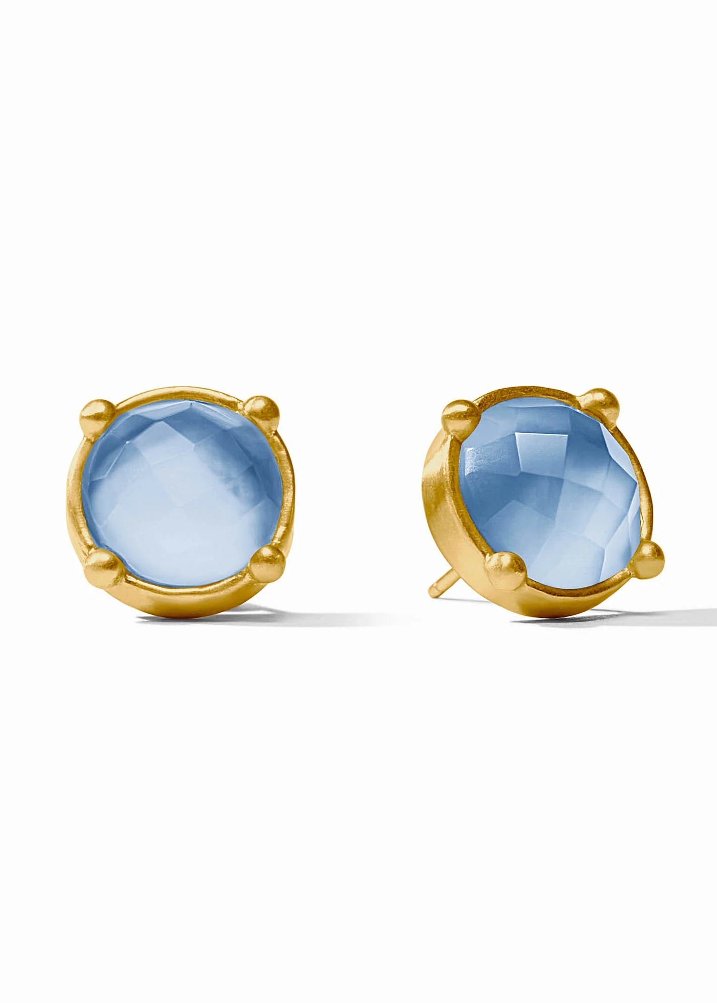 Gold earrings with blue gemstones on a white background